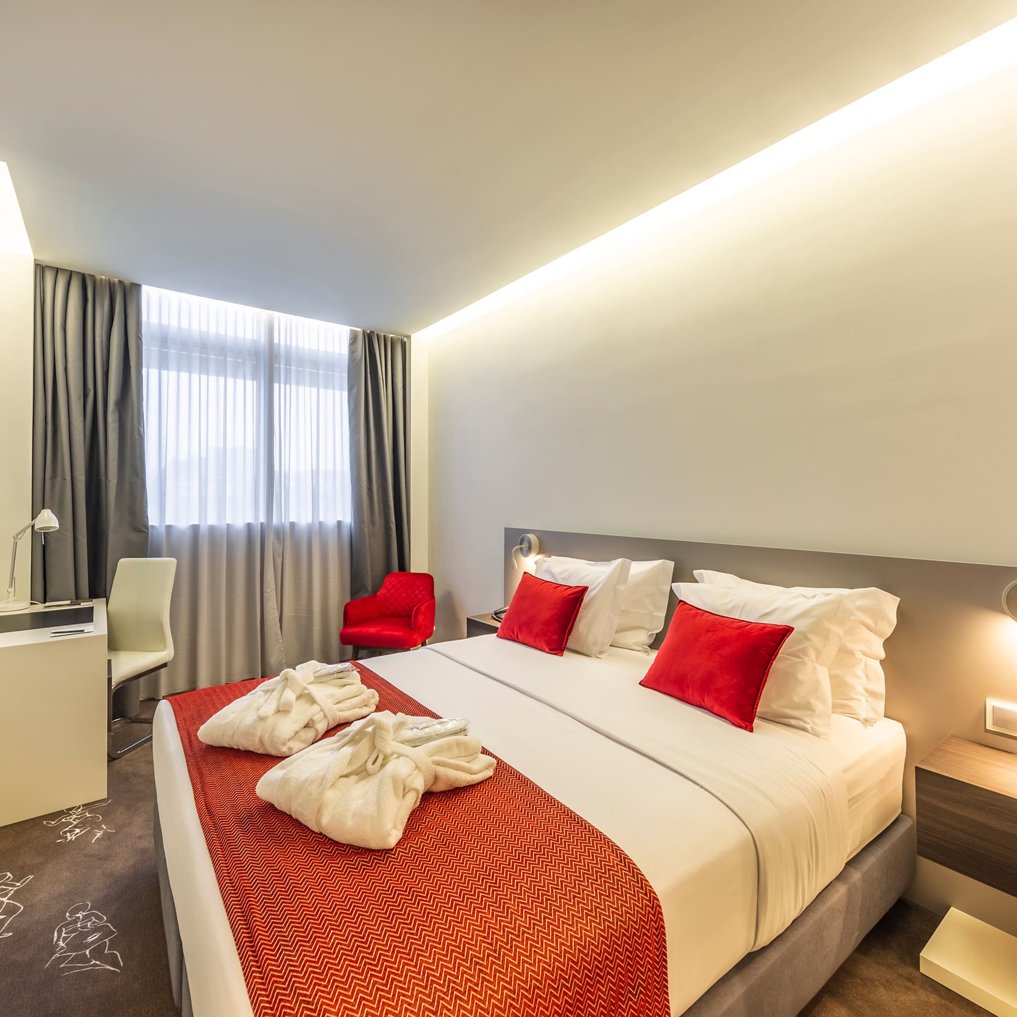 a bed with red and white pillows