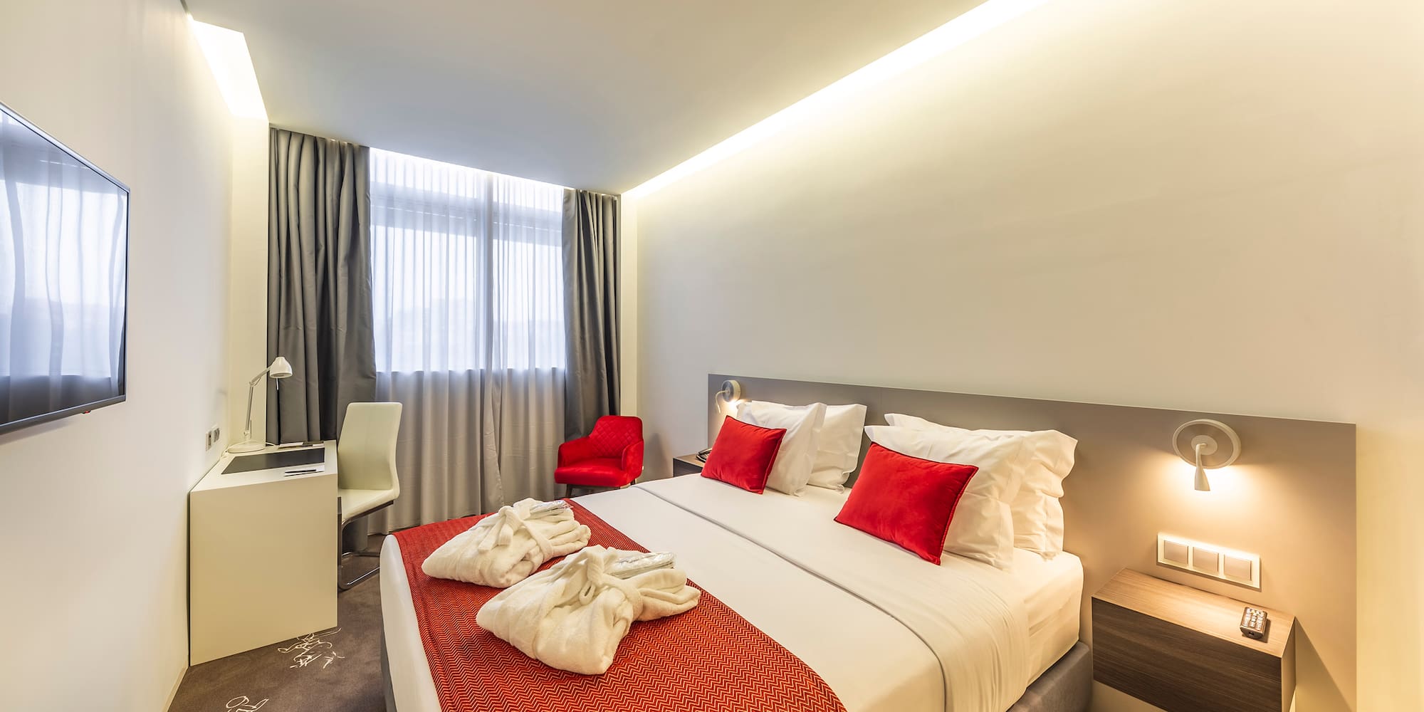 a bed with red and white pillows