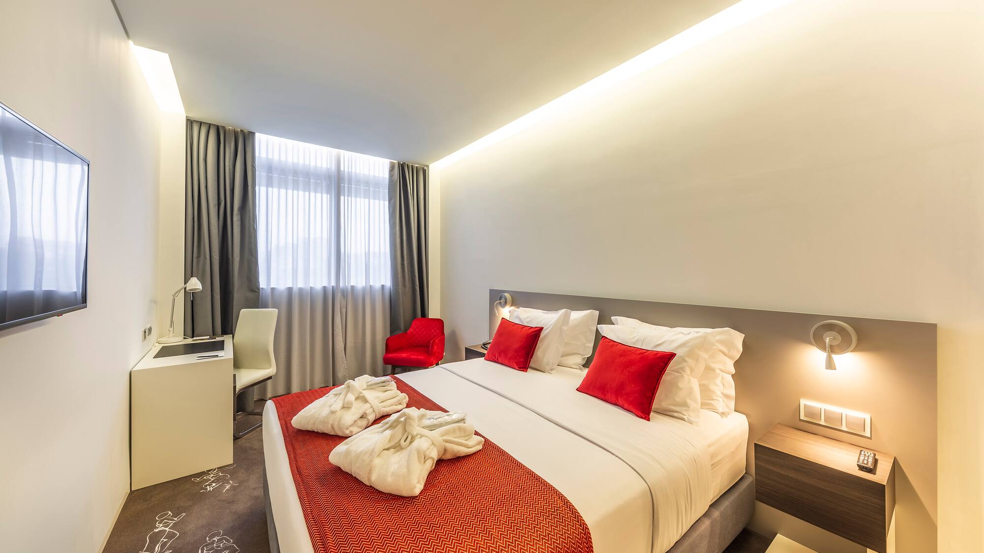 a bed with red and white pillows