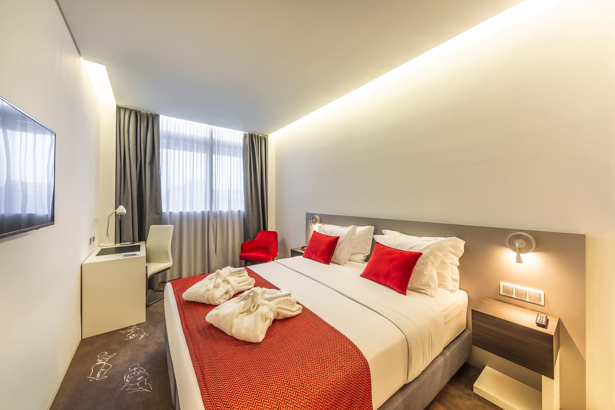 a bed with red and white pillows