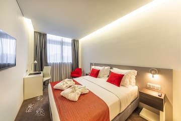 a bed with red and white pillows