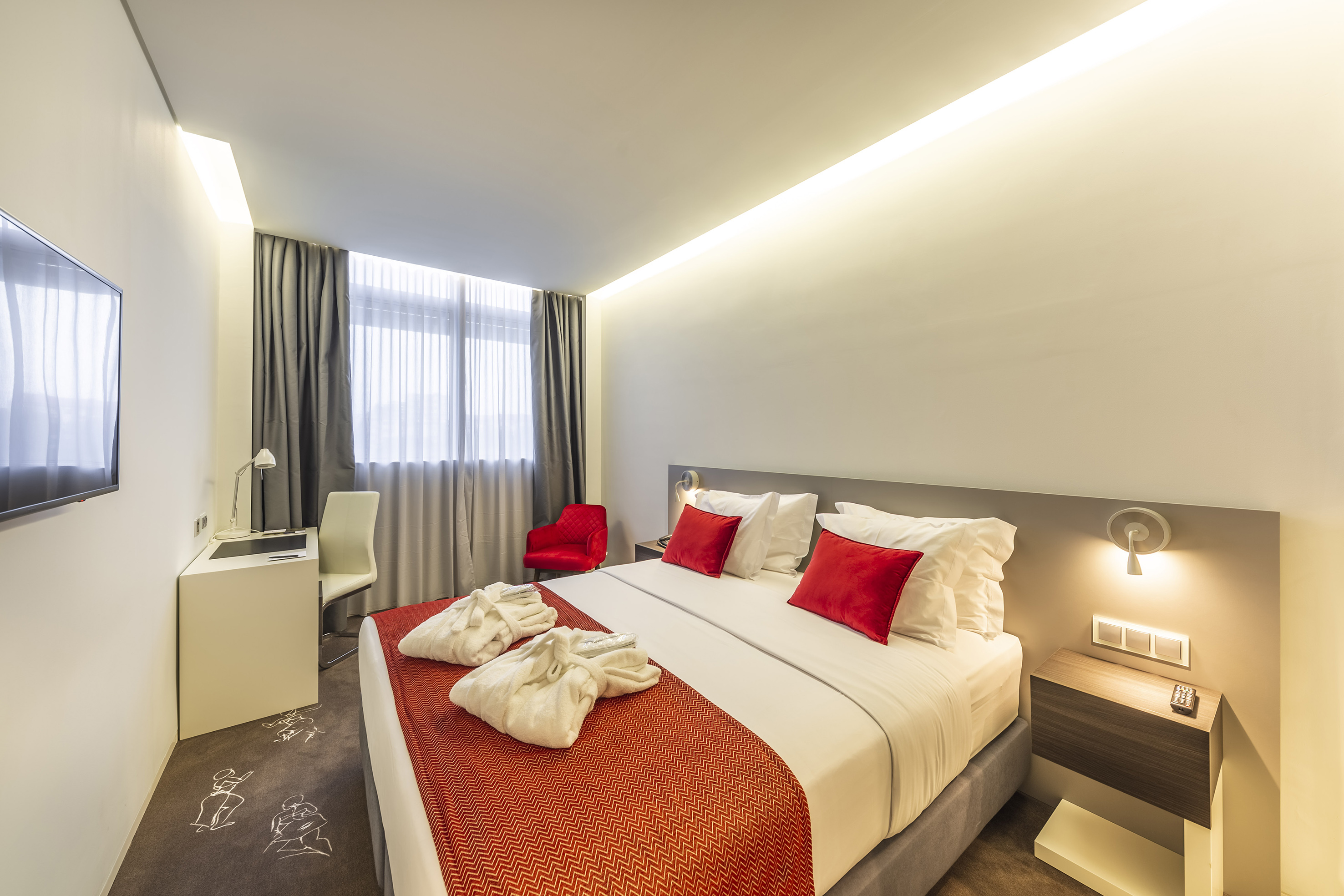 a bed with red and white pillows