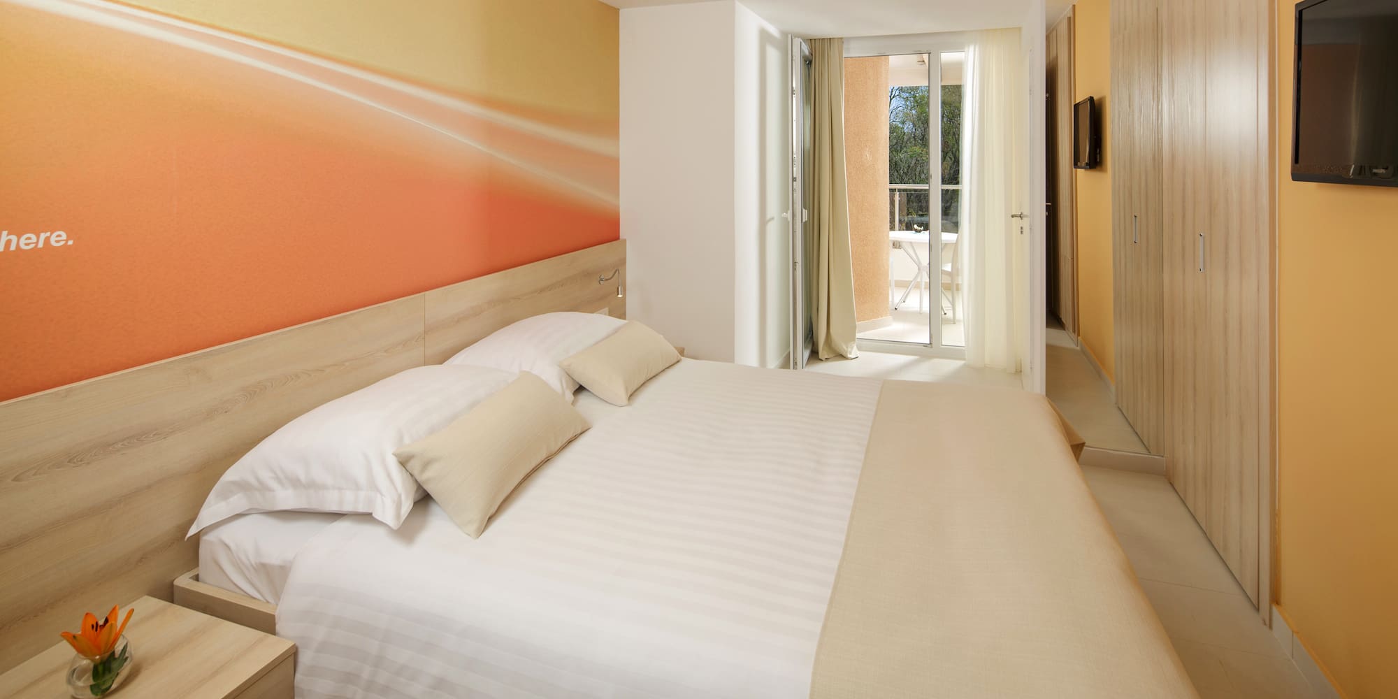 a bed with pillows and a wallpaper on the wall