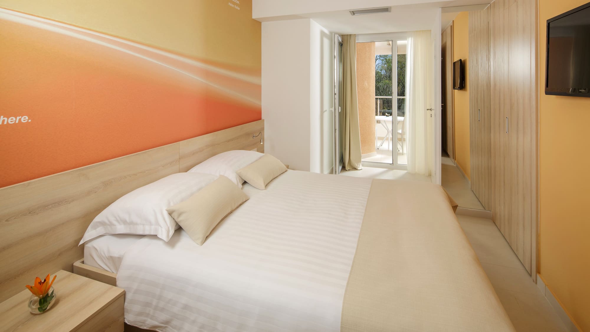 a bed with pillows and a wallpaper on the wall