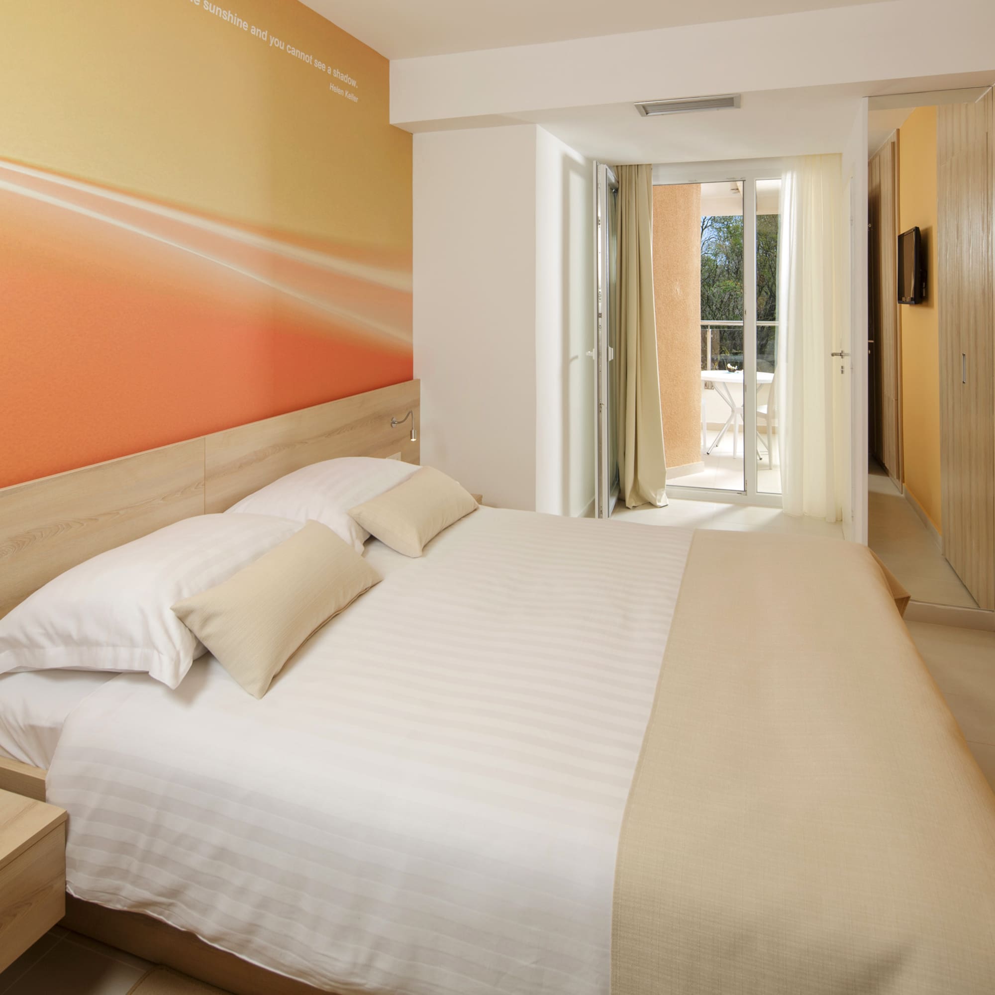 a bed with pillows and a wallpaper on the wall