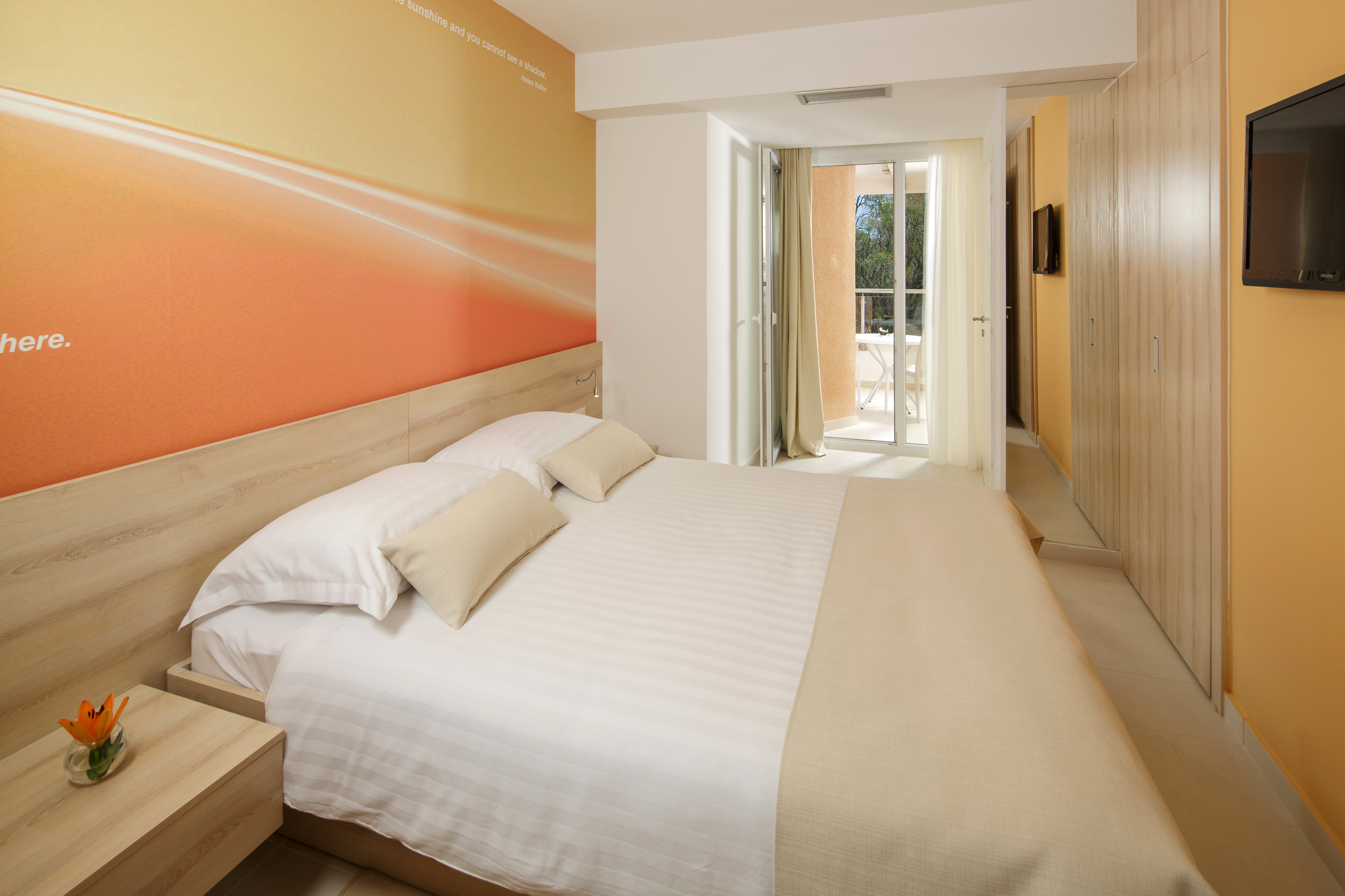 a bed with pillows and a wallpaper on the wall