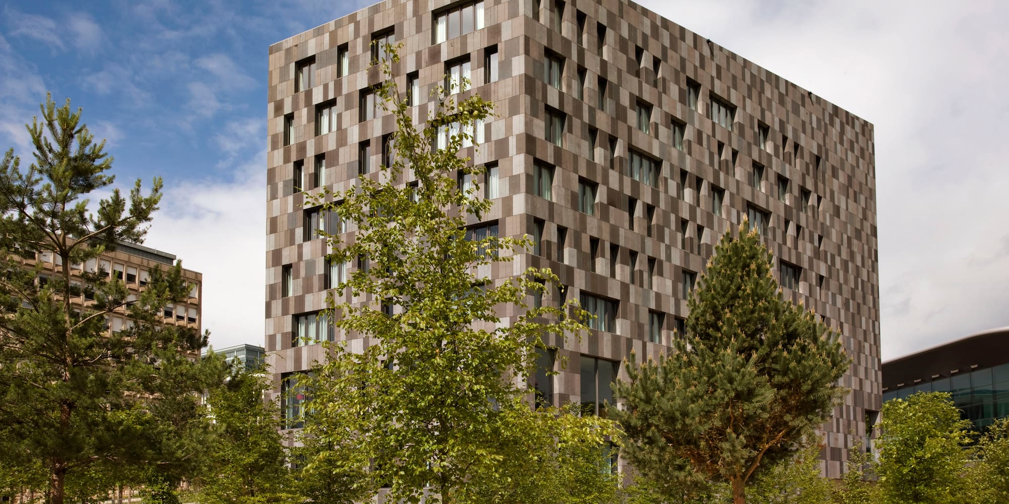 a building with trees and a sidewalk