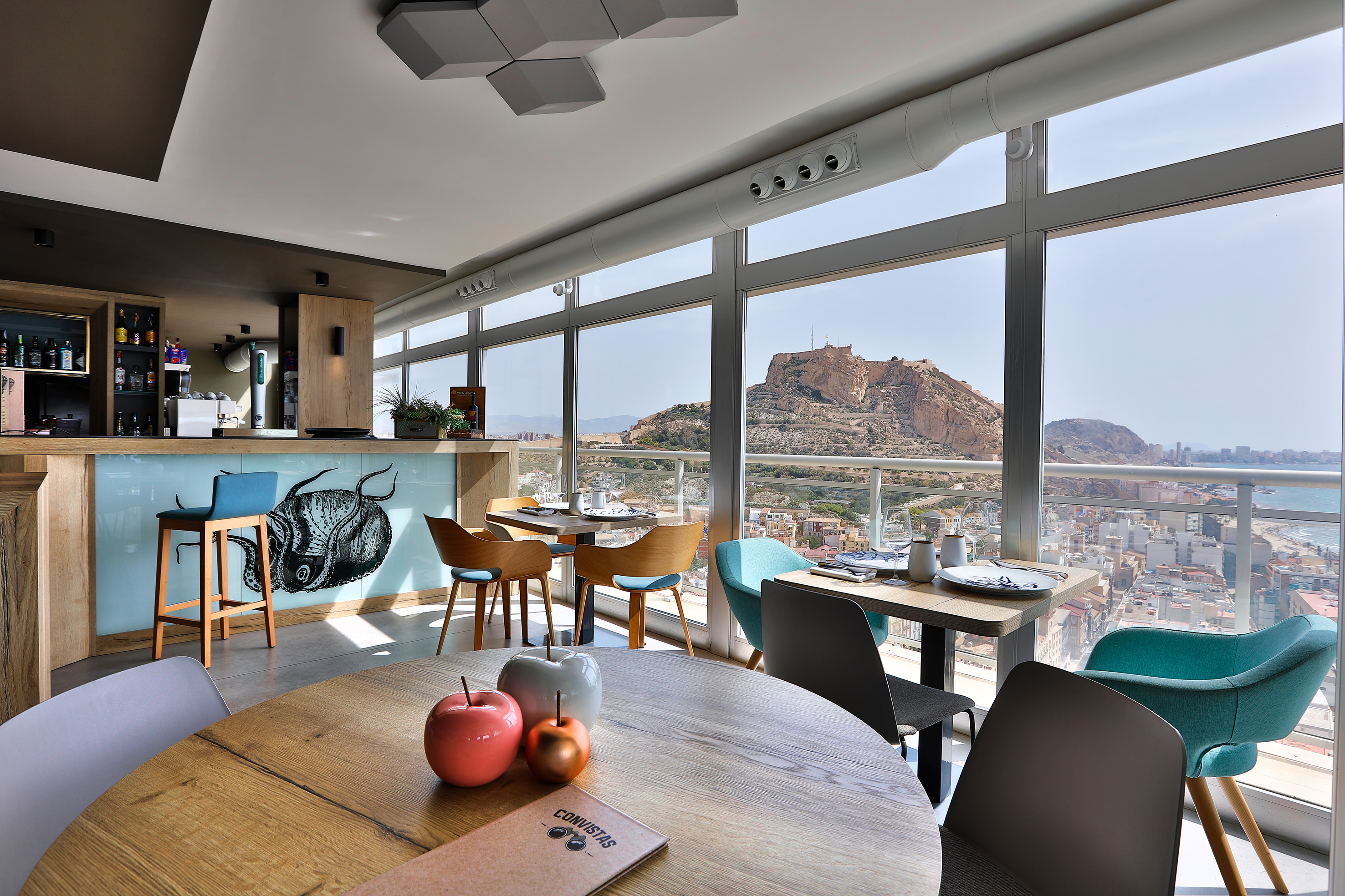 Modern restaurant bar with panoramic Alicante city, castle, sea views.