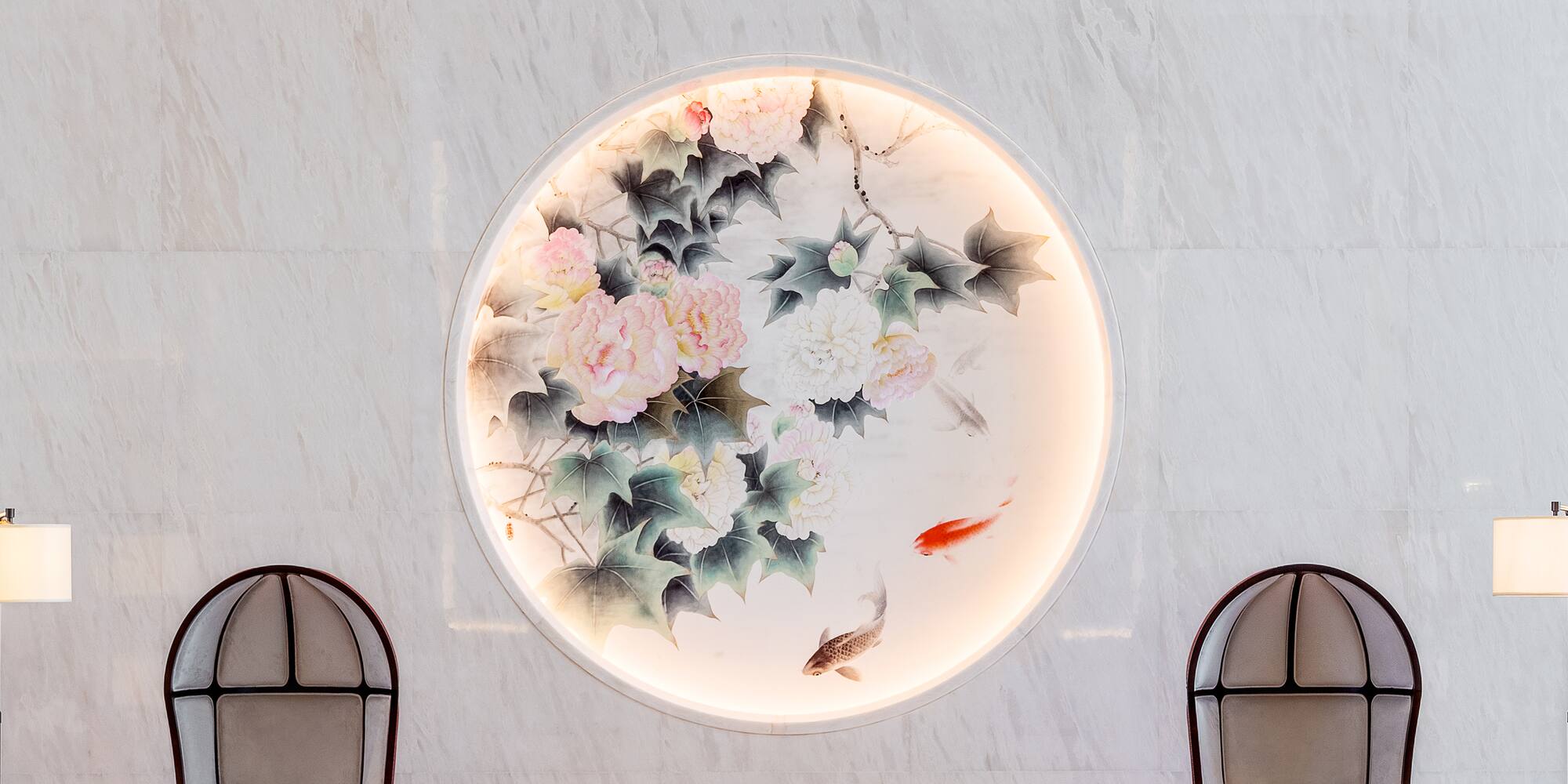 a circular light fixture with a painting of flowers and fish