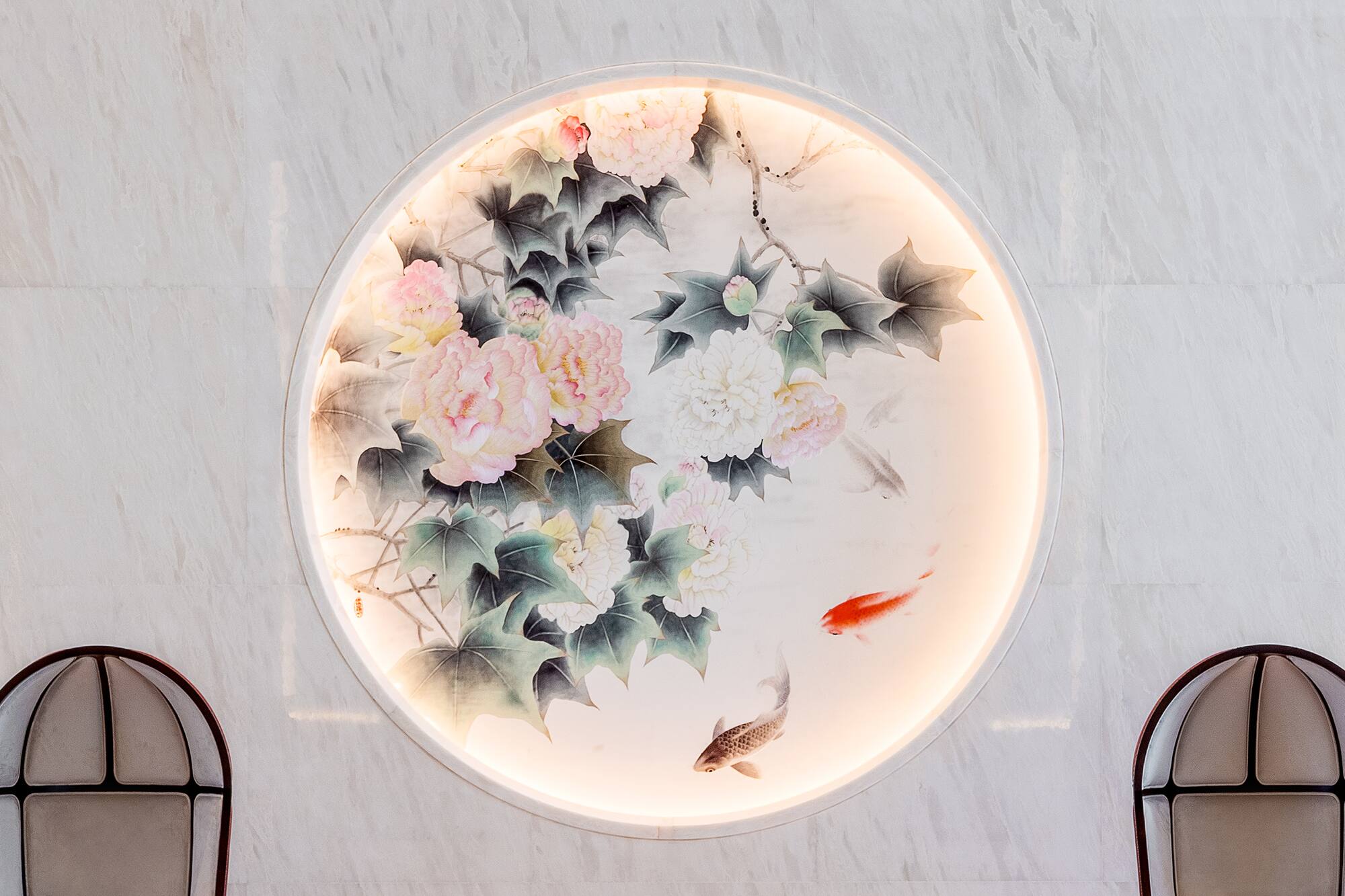 Chinese circular art: backlit peonies & koi fish on white marble.