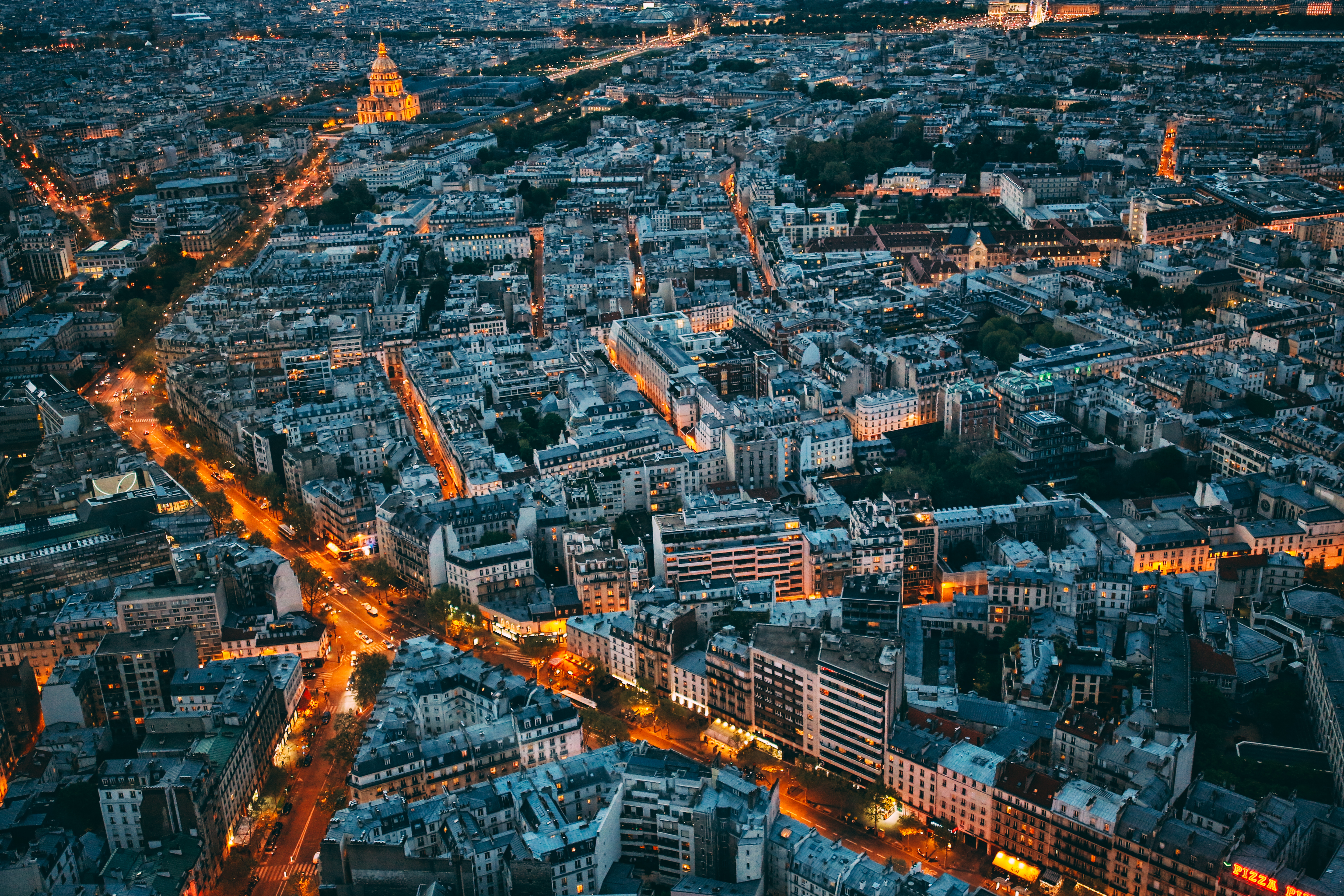 Vista aérea nocturna de París, Les Invalides y calles iluminadas con tráfico.