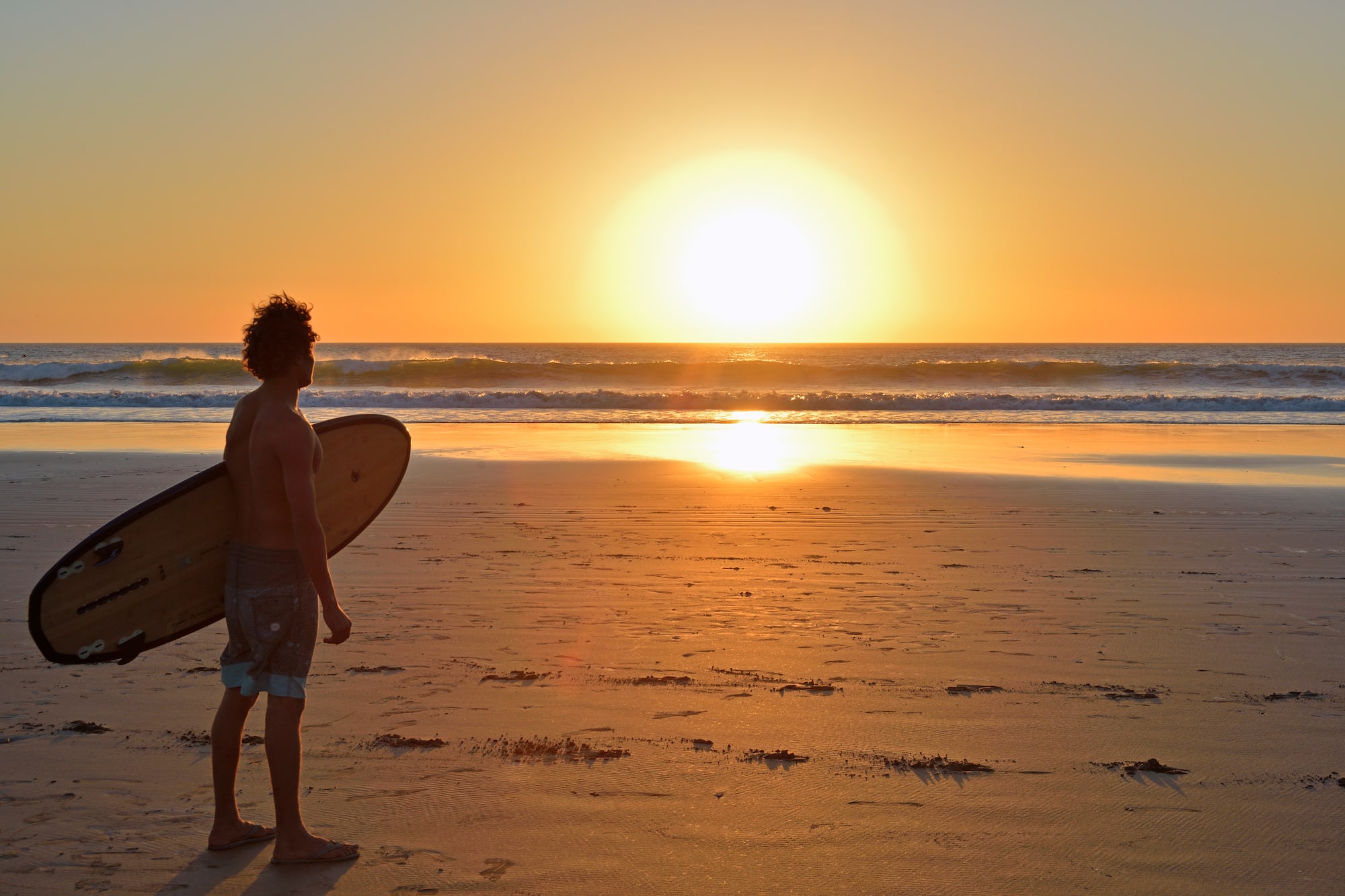 a man holding a surfboard on a beach