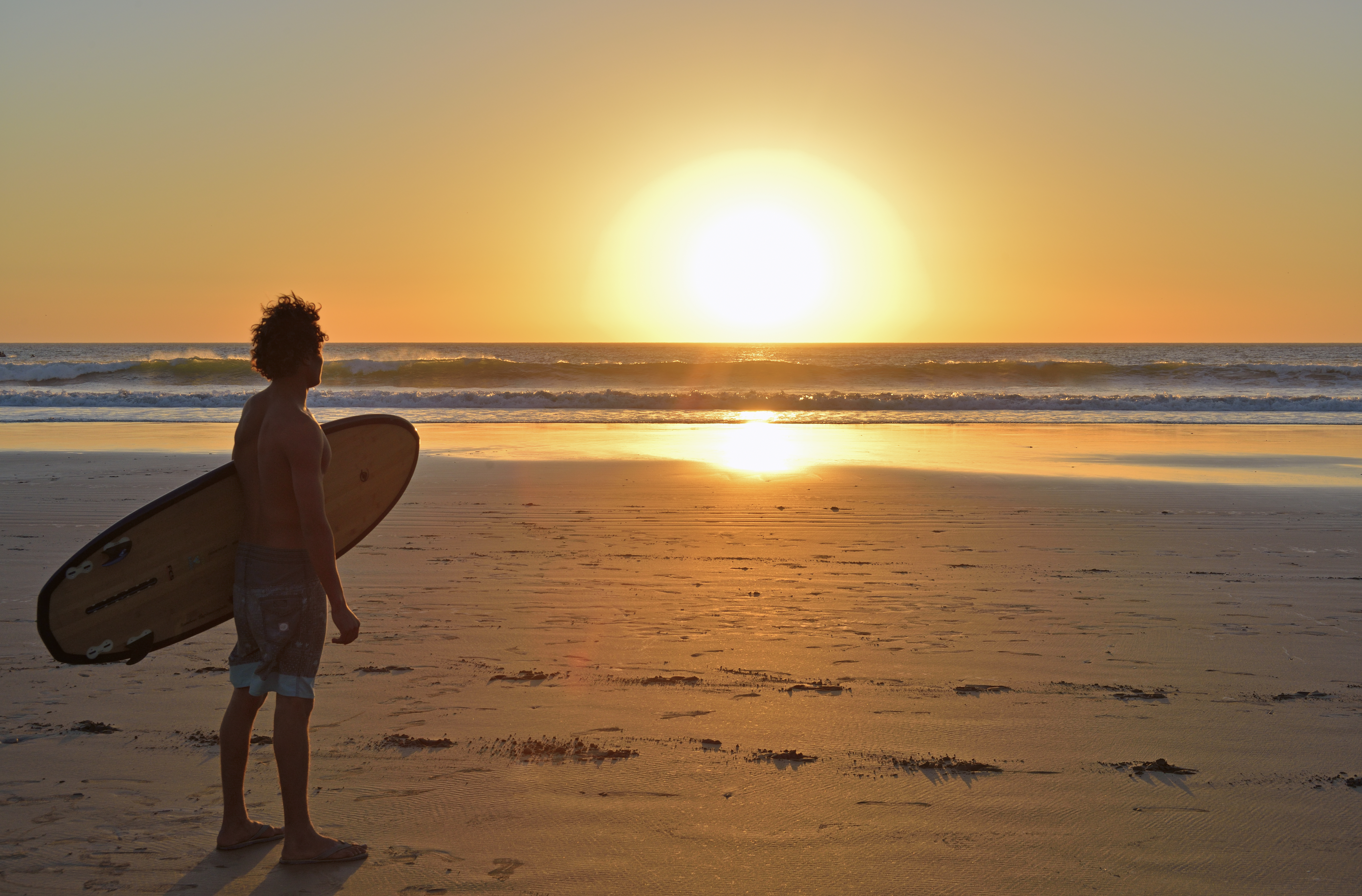 a man holding a surfboard on a beach