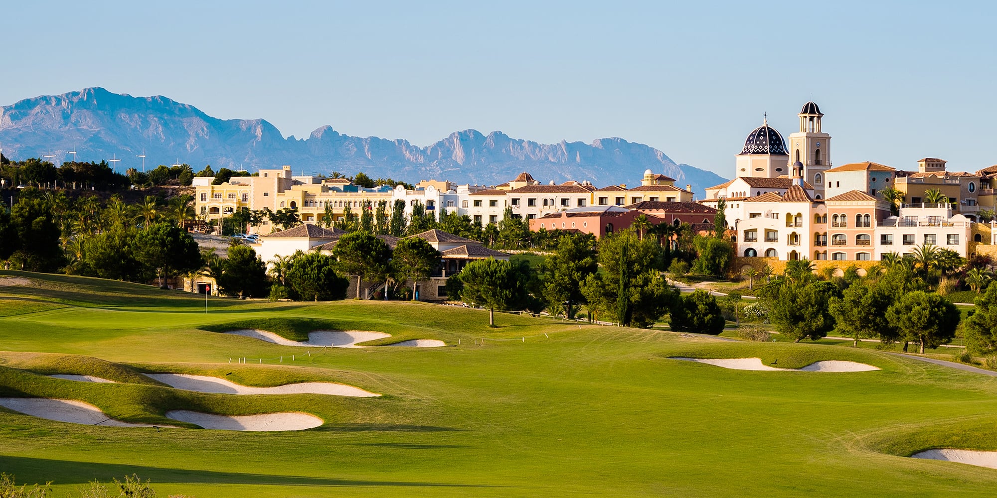a golf course with a large building in the background