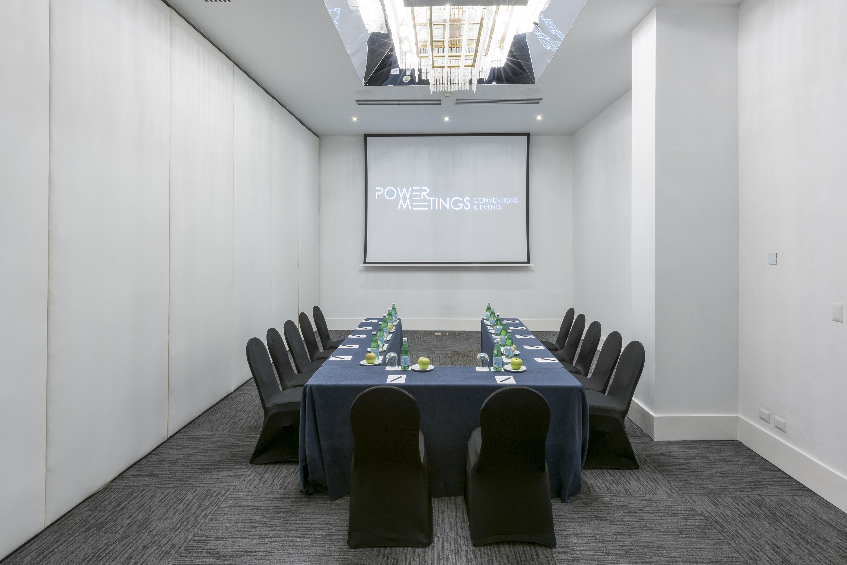 U-shaped conference room setup with projector screen, ideal for meetings and events.