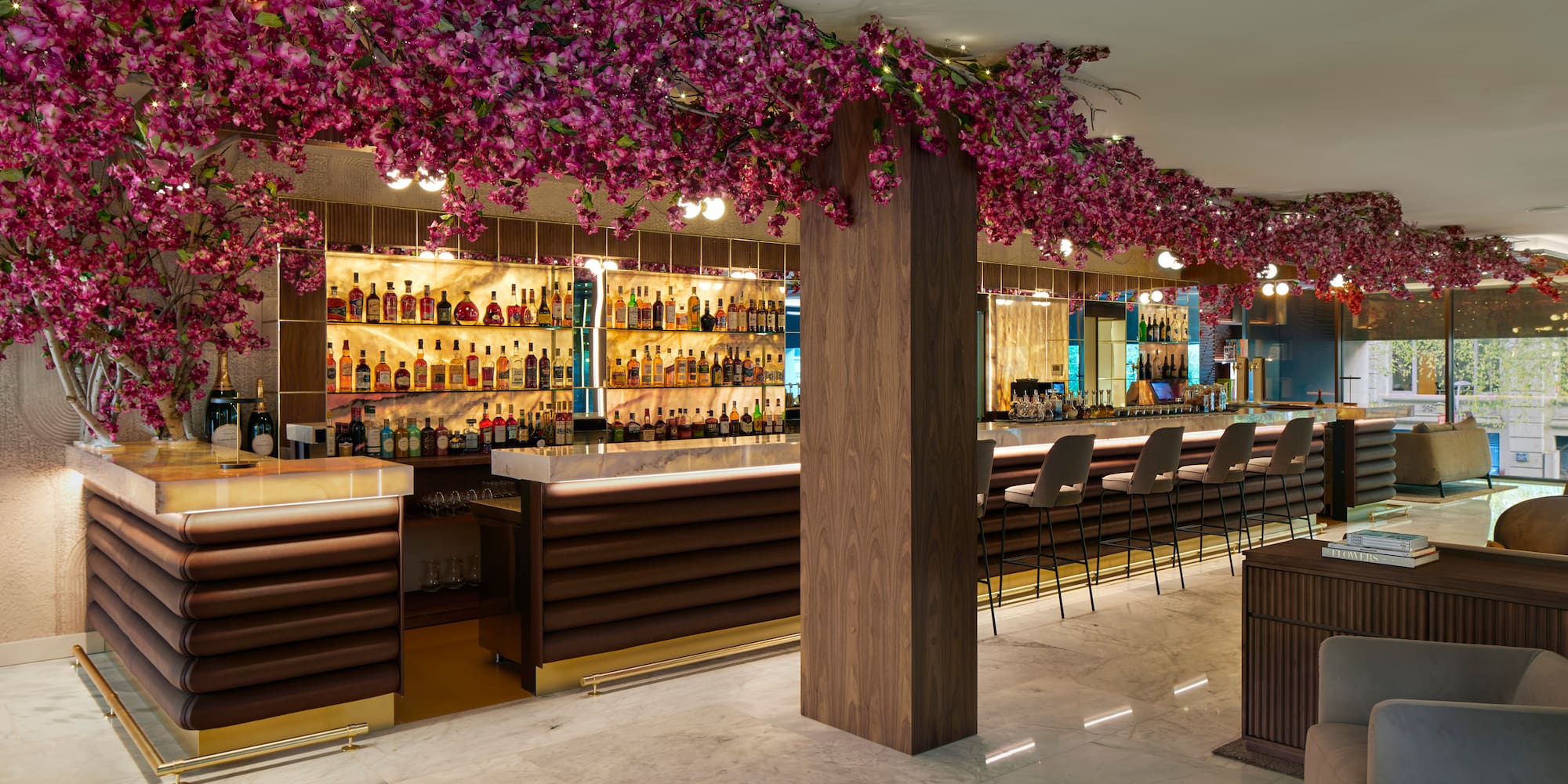 a bar with purple flowers from the ceiling