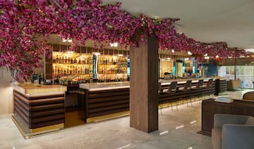 a bar with purple flowers from the ceiling