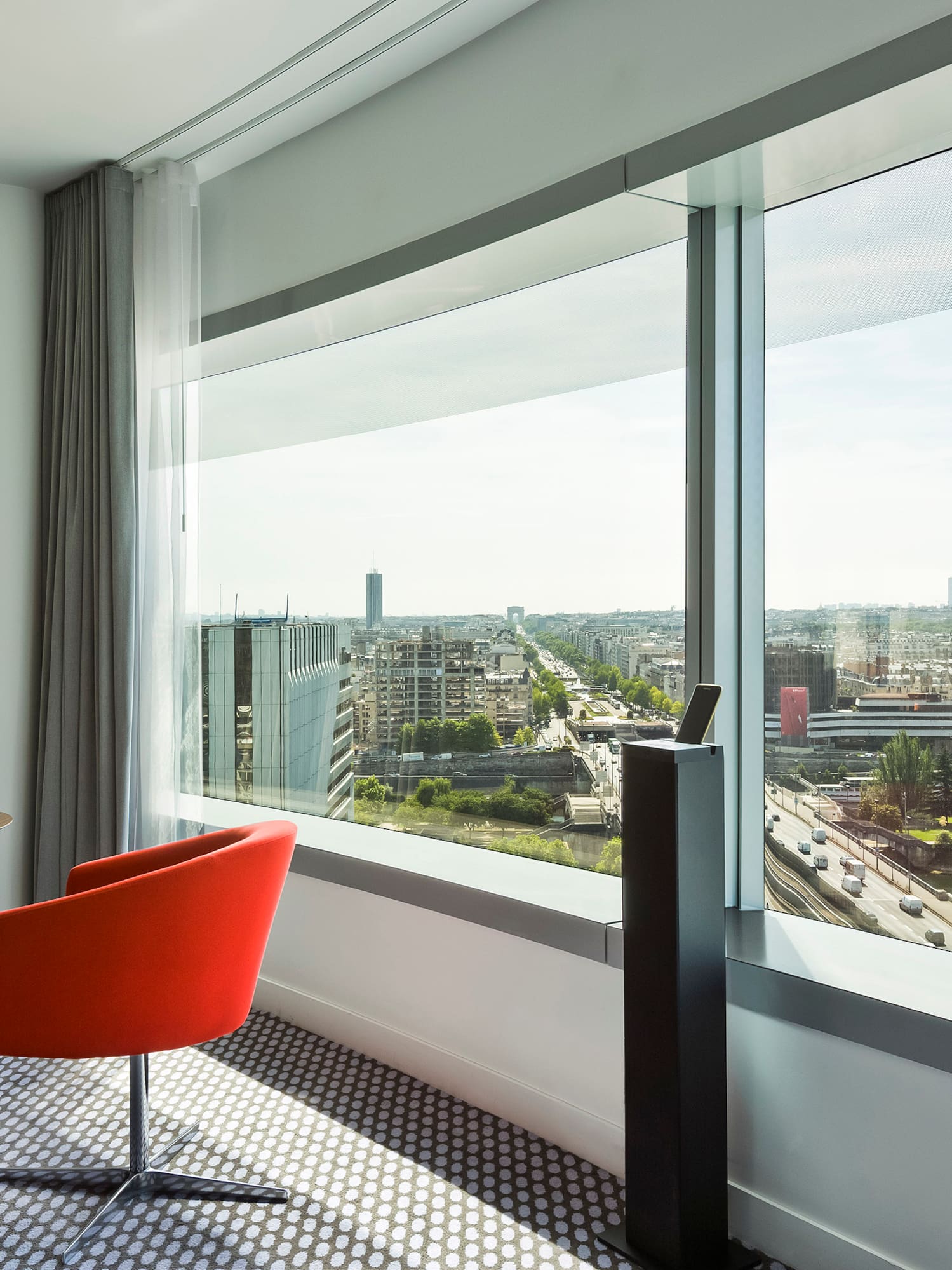 Modern hotel room with panoramic Paris view, Eiffel Tower, and Seine River.