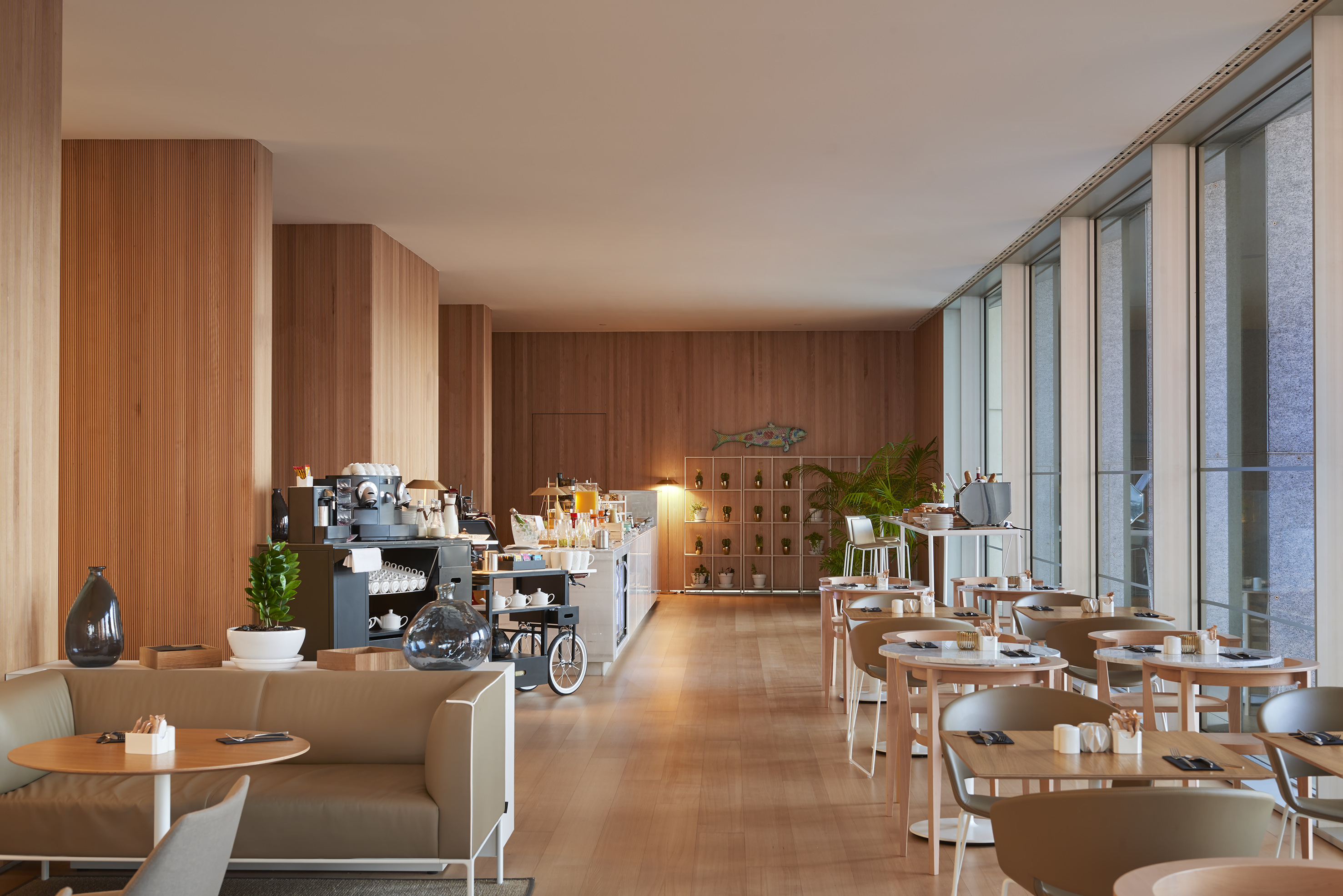 Modern restaurant with wood paneling, buffet, and window seating.