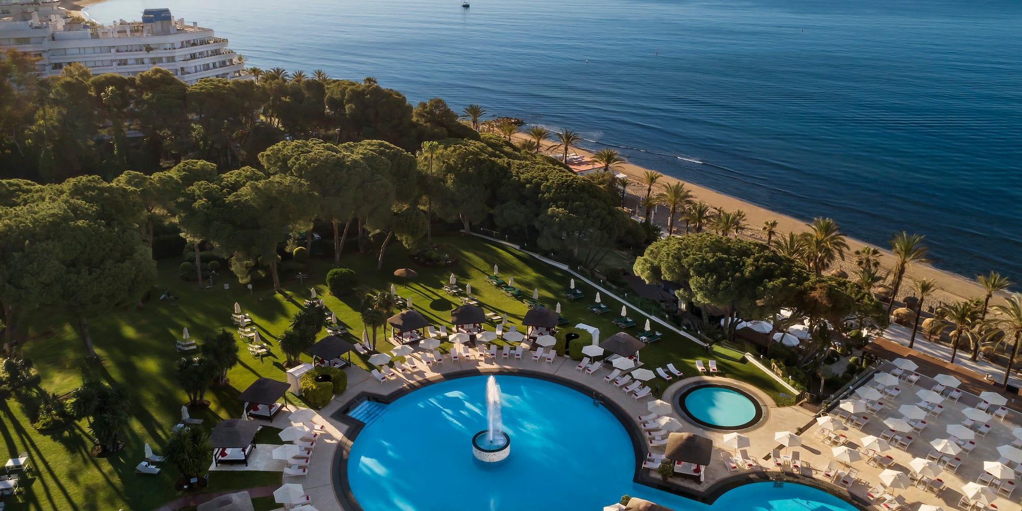 a pool with a fountain in the middle of a resort