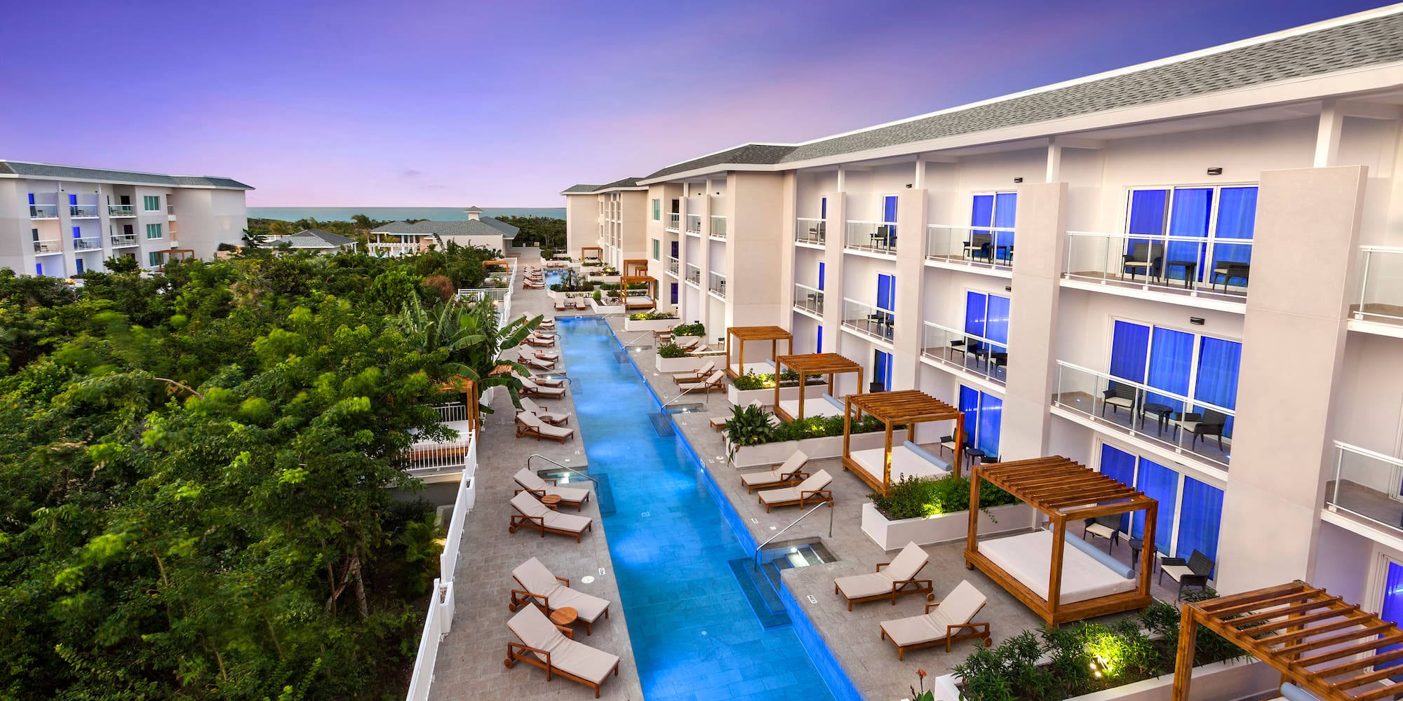a pool with lounge chairs and trees in the background