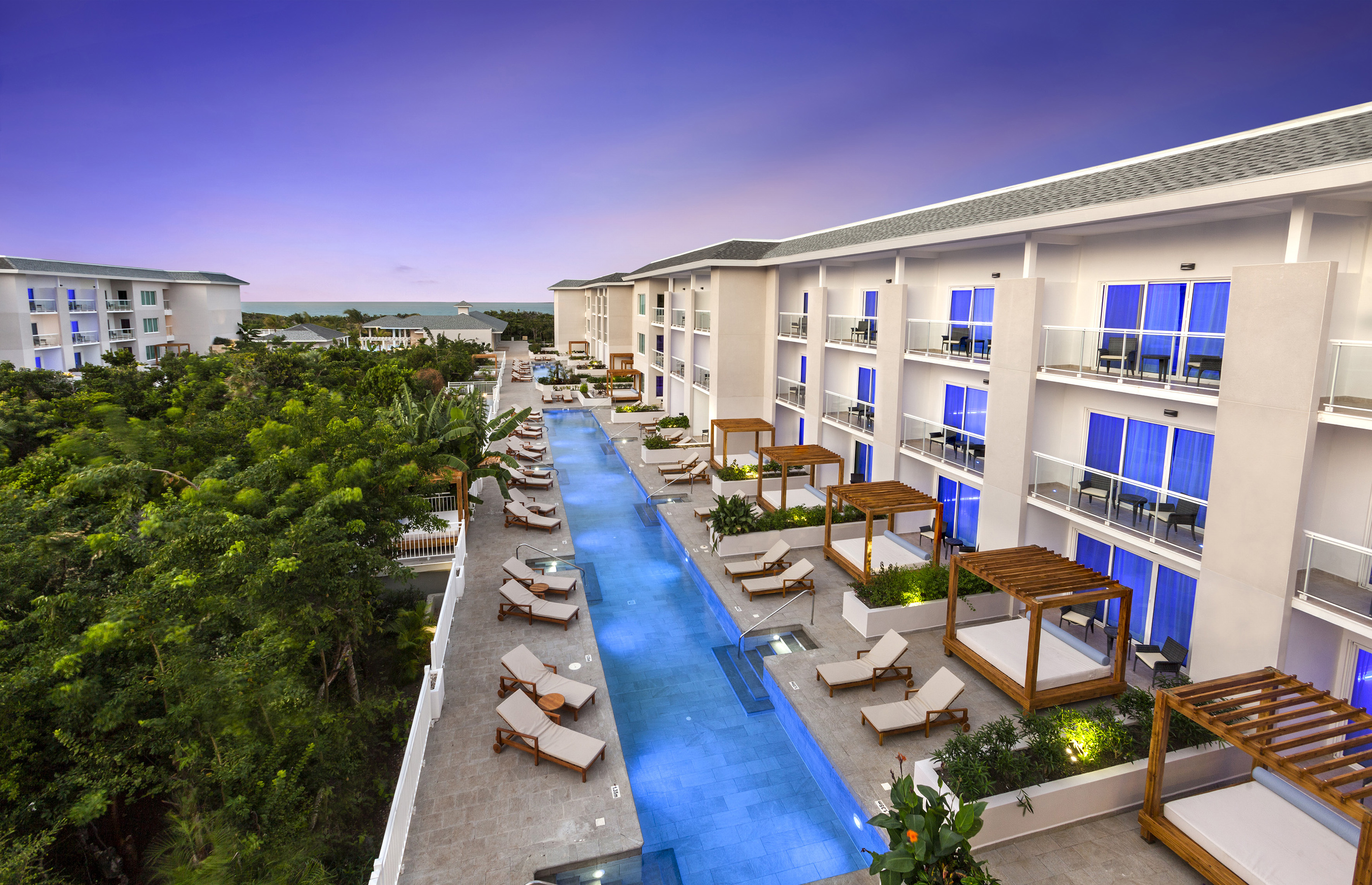 a pool with lounge chairs and trees in the background