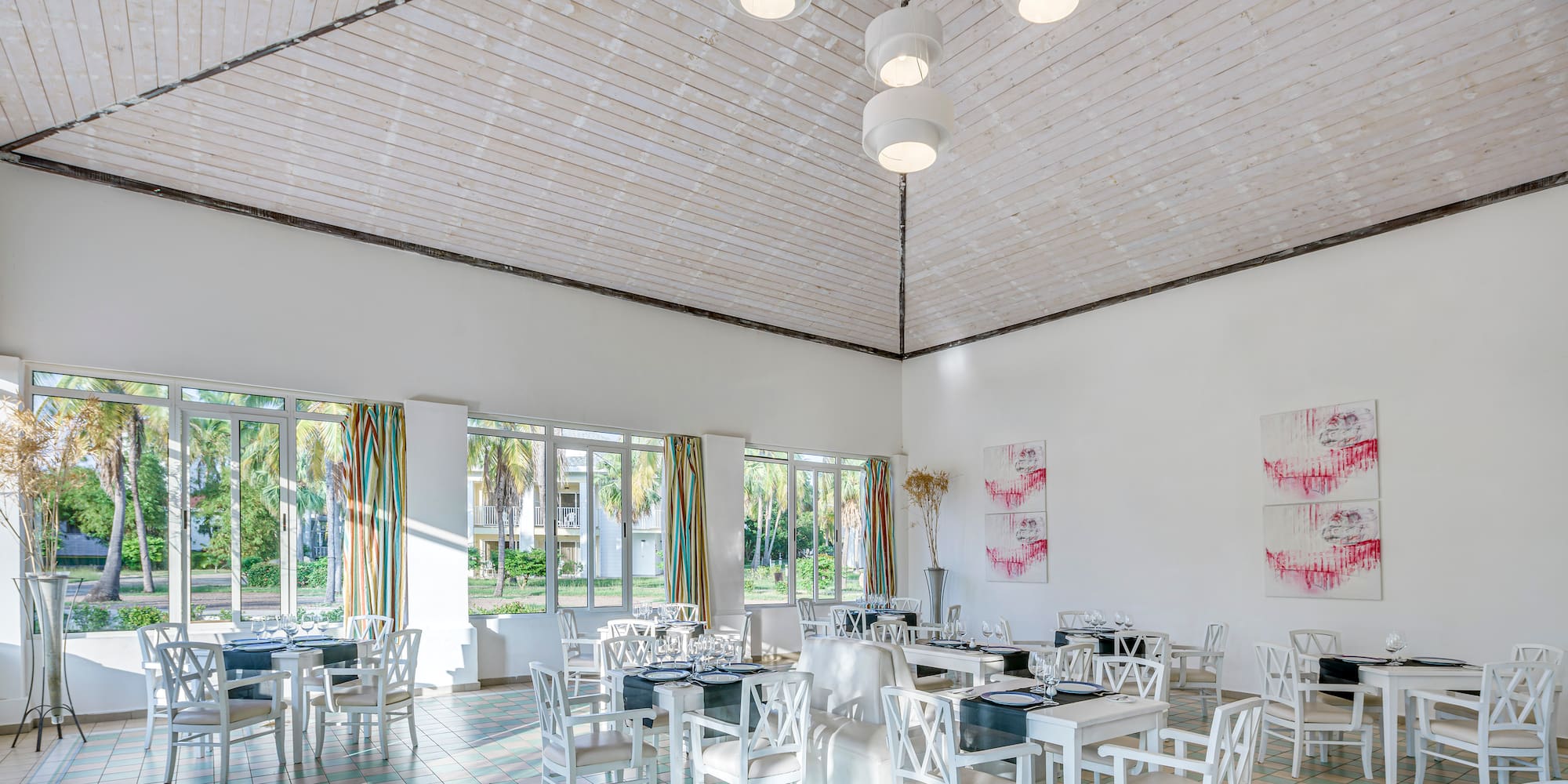 a room with white chairs and tables