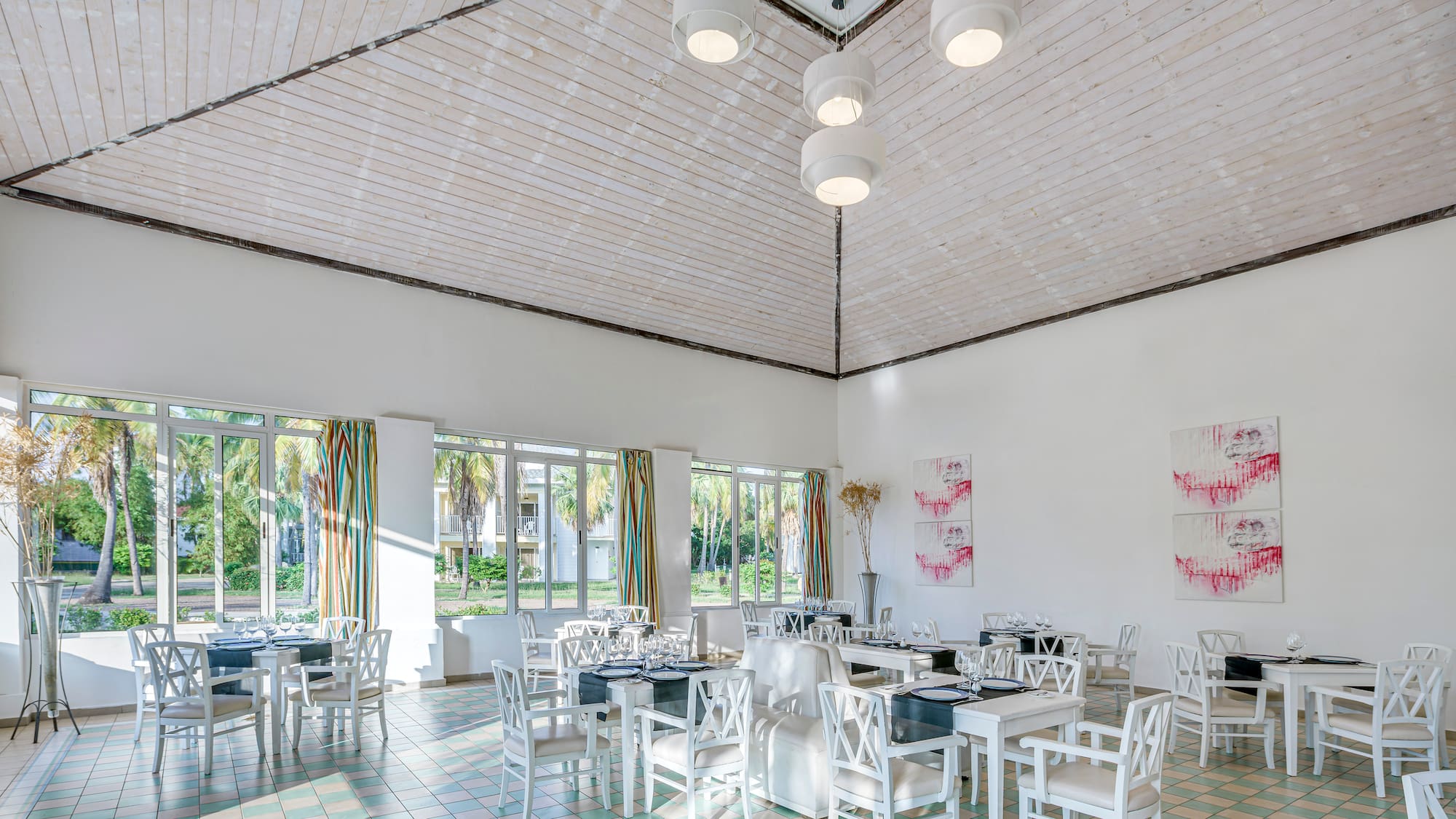 a room with white chairs and tables