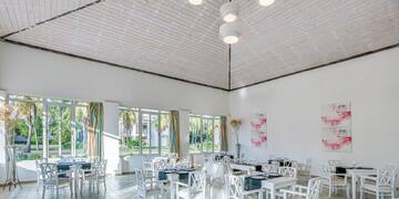 a room with white chairs and tables
