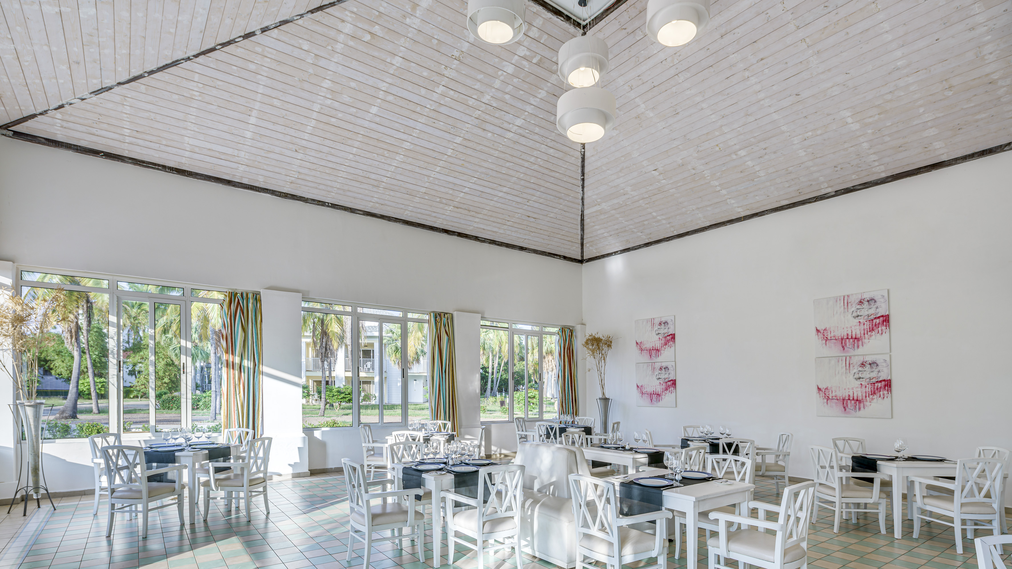 a room with white chairs and tables