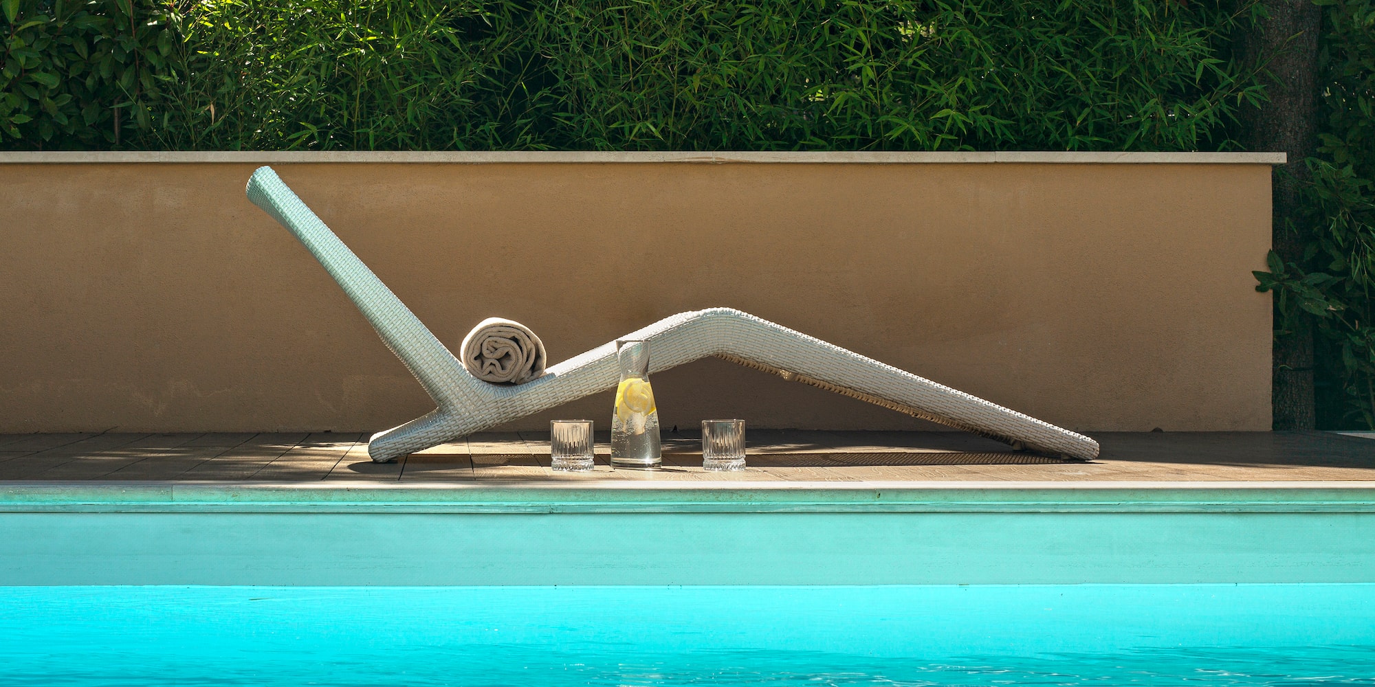 a pool with a white chair and glasses on the side