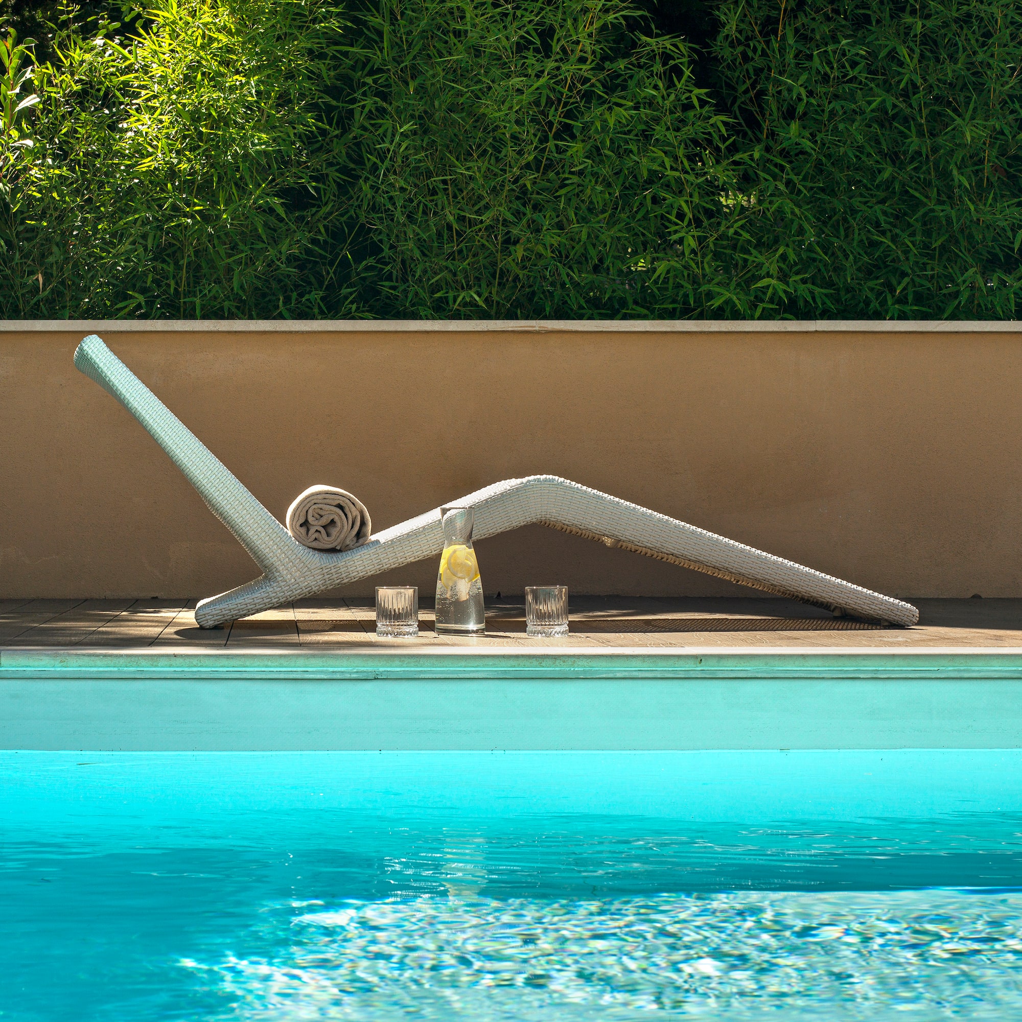 a pool with a white chair and glasses on the side
