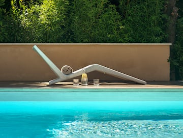 a pool with a white chair and glasses on the side