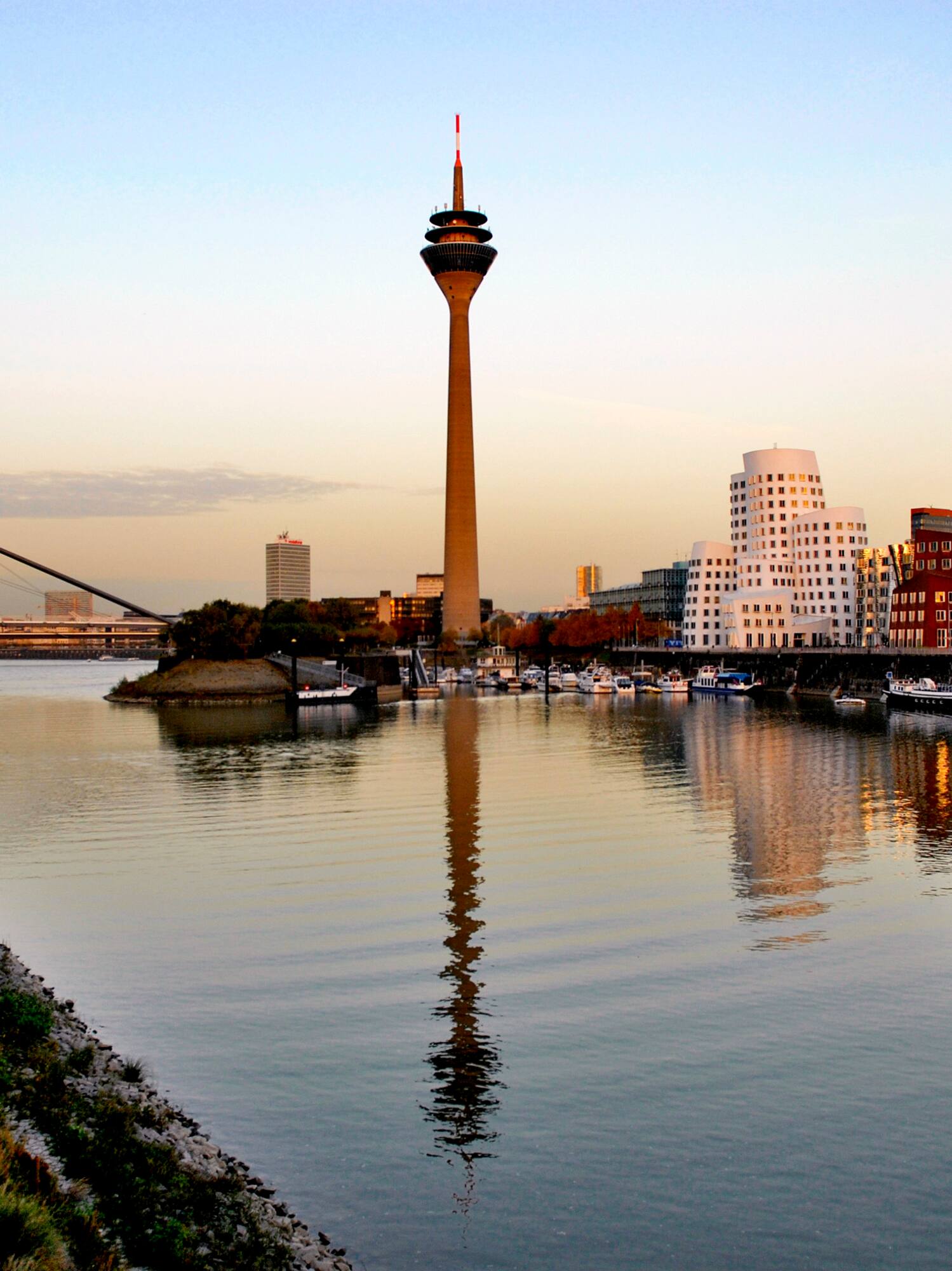 Düsseldorf Rheinturm, Media Harbour reflecting in Rhine River at dusk.
