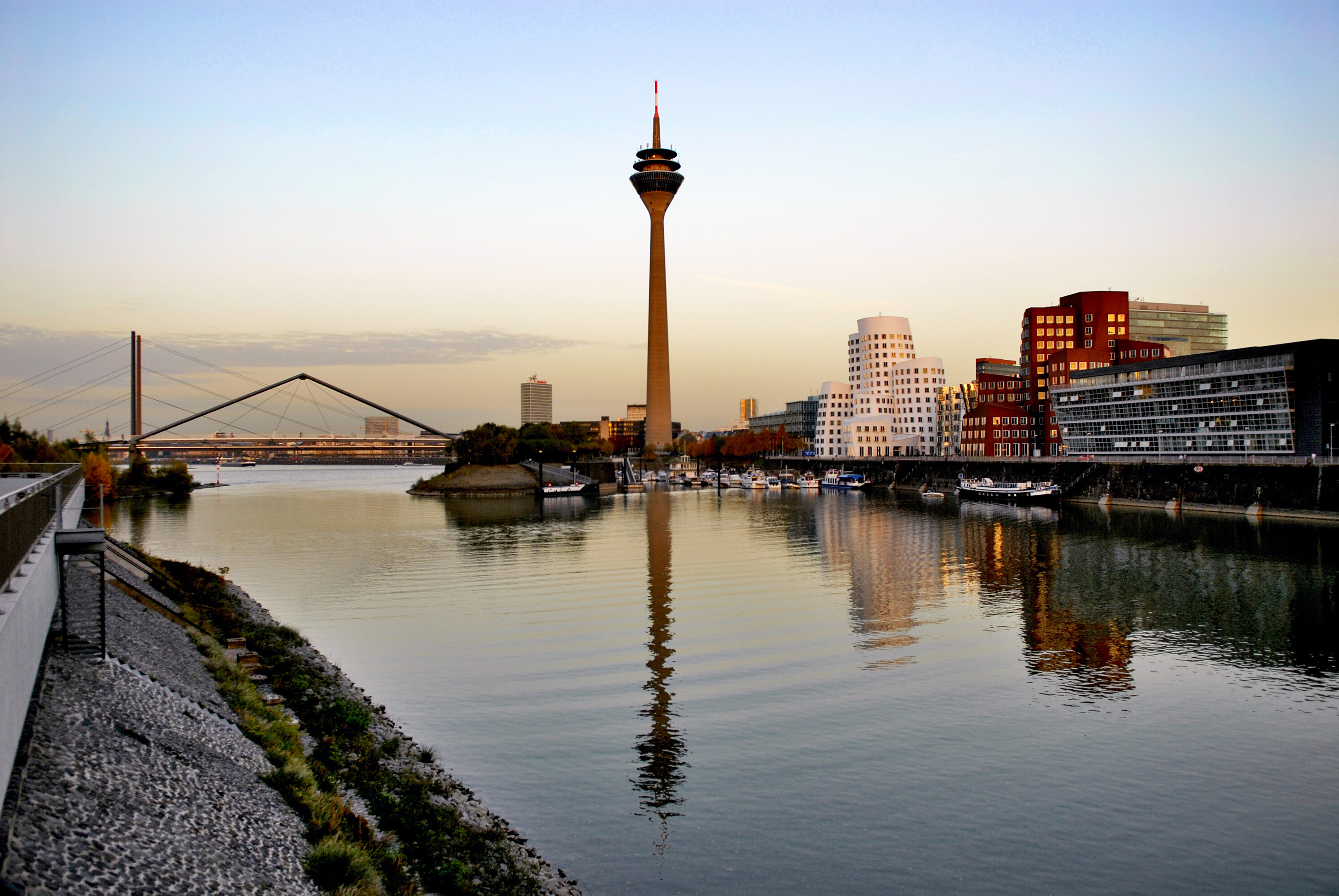 Düsseldorf Rheinturm, Media Harbour reflecting in Rhine River at dusk.