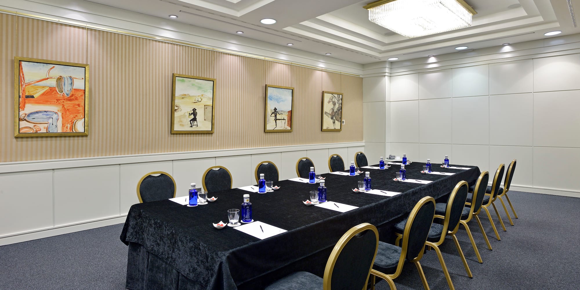 a long conference table with blue chairs and a black tablecloth