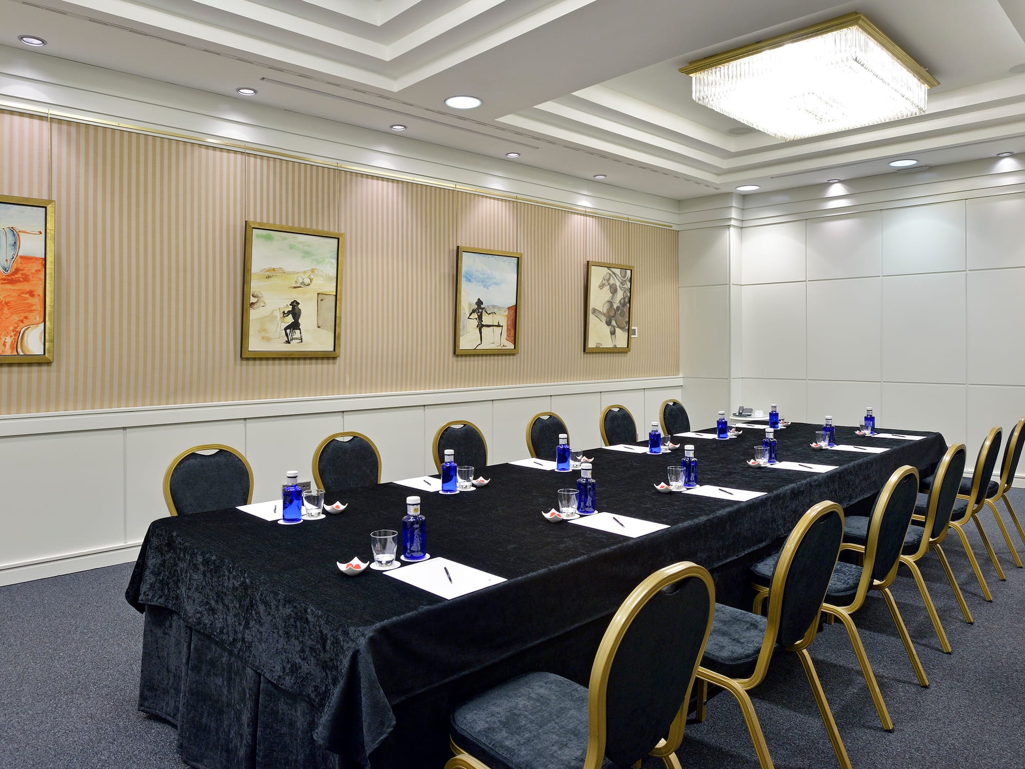 a long conference table with blue chairs and a black tablecloth