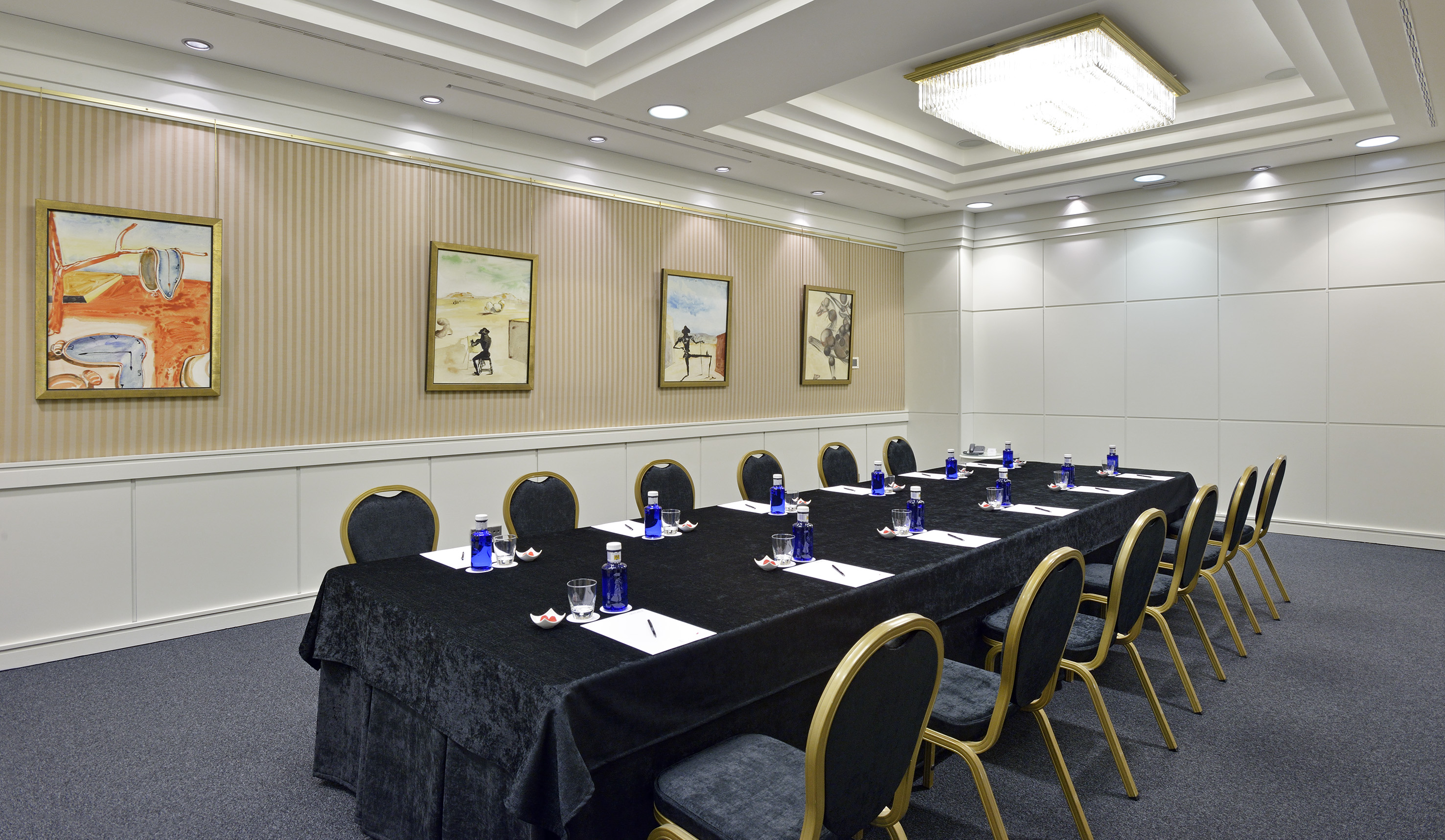a long conference table with blue chairs and a black tablecloth
