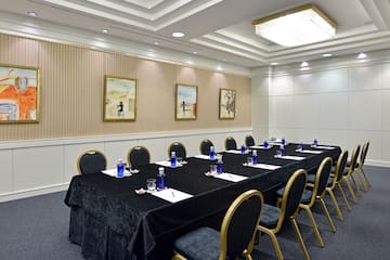 a long conference table with blue chairs and a black tablecloth