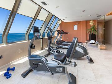 a room with exercise bikes and a window overlooking the ocean