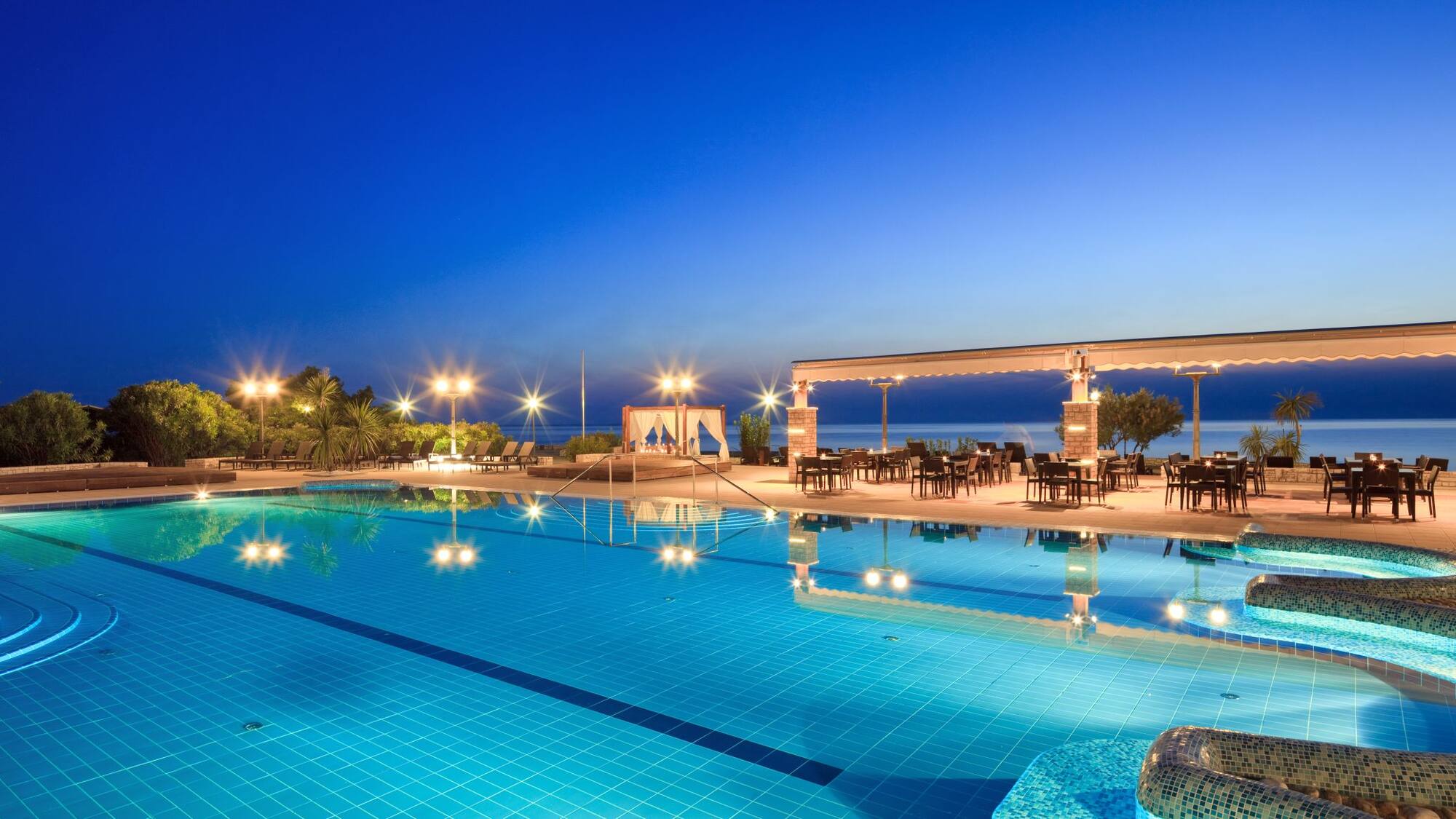 a swimming pool with a gazebo and chairs