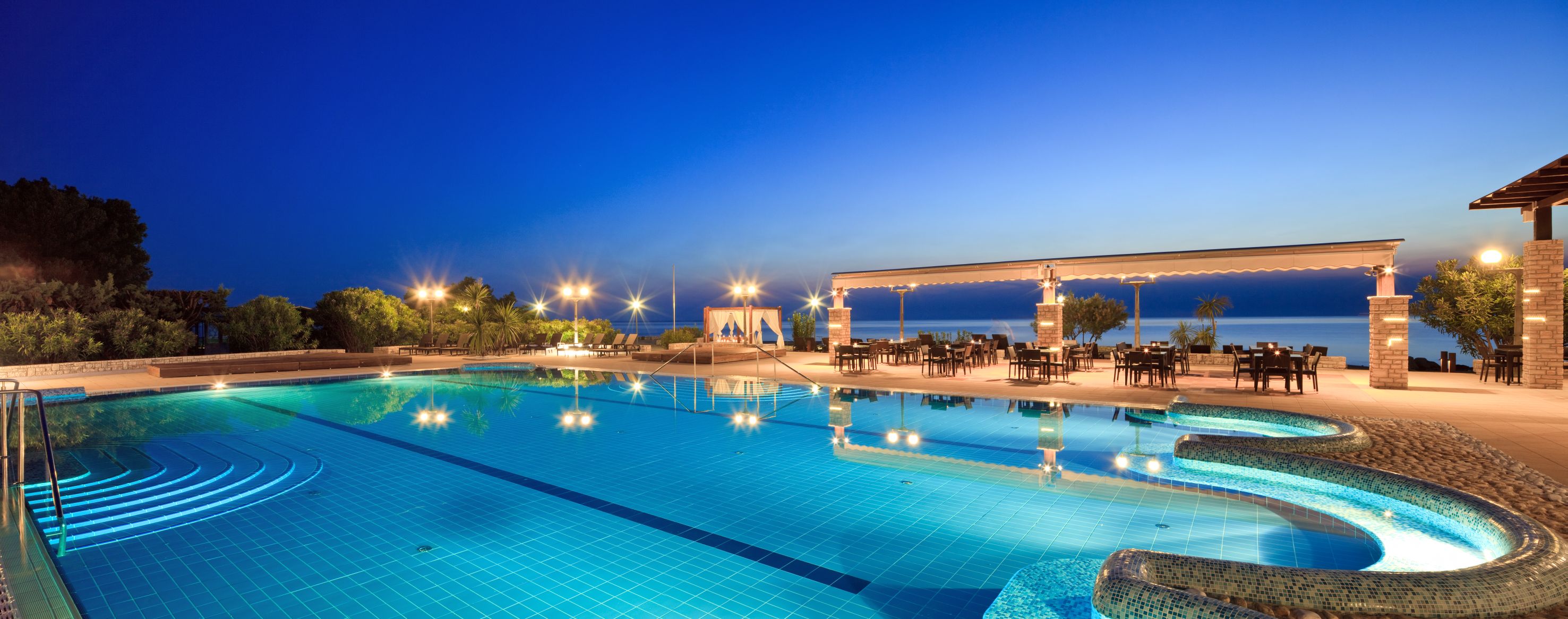 a swimming pool with a gazebo and chairs
