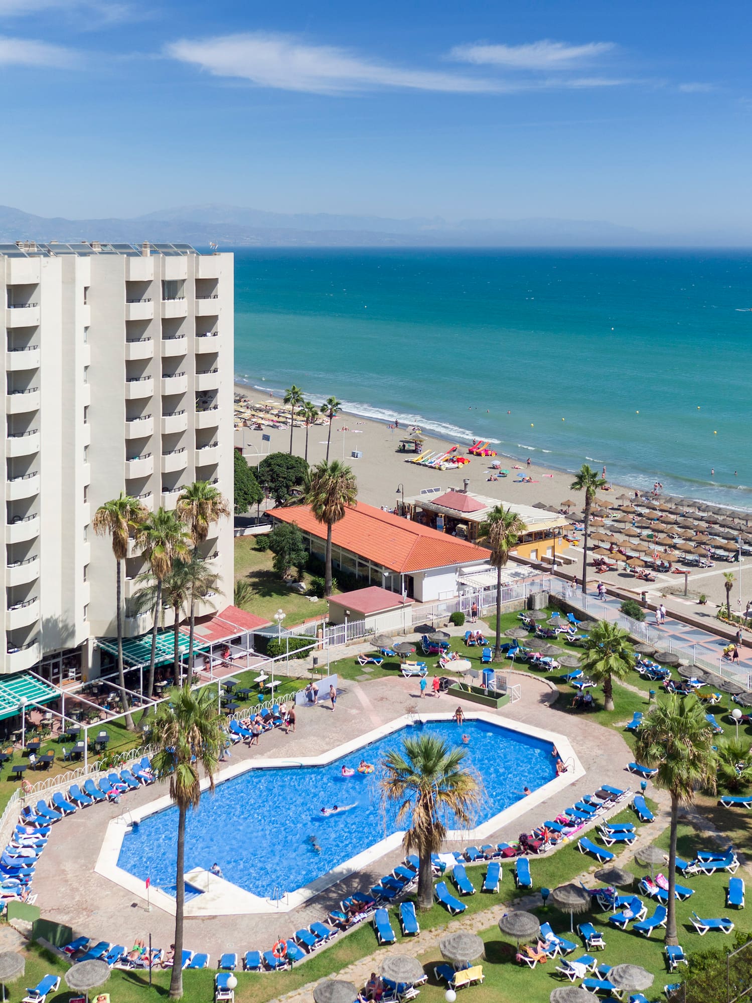 a swimming pool and a large building by the ocean