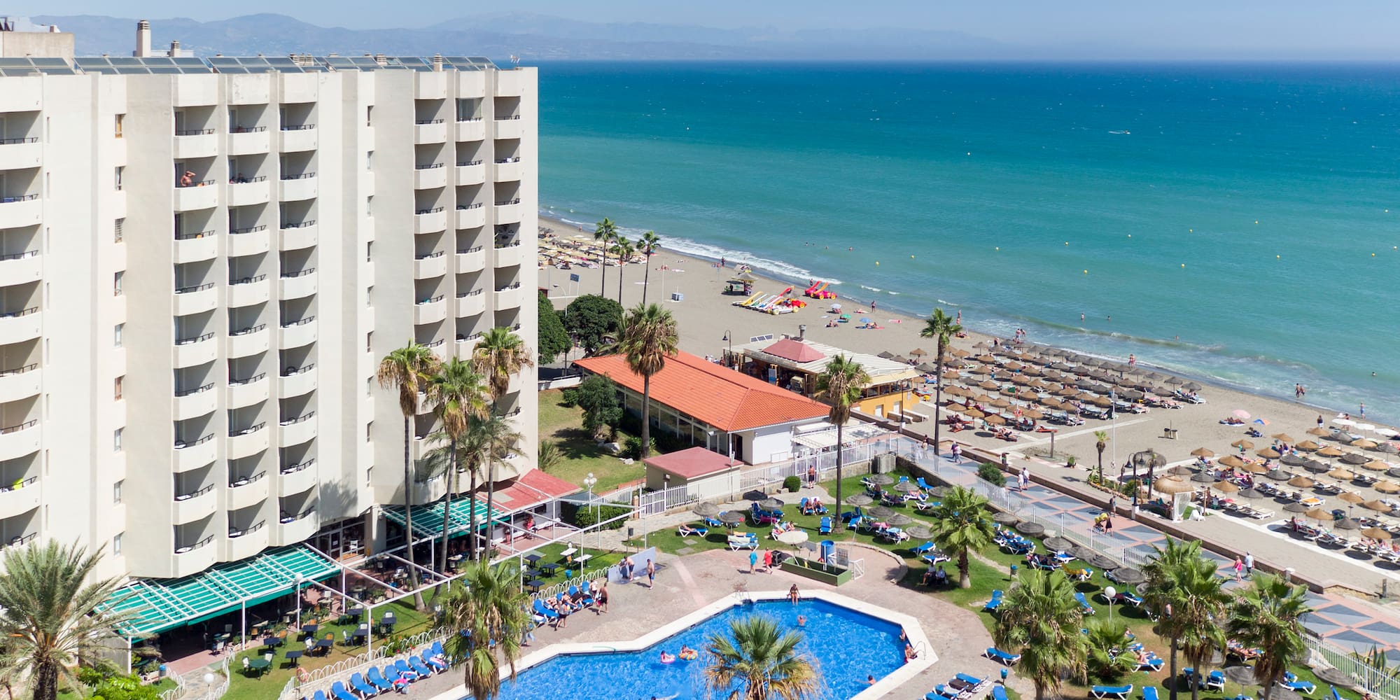 a swimming pool and a large building by the ocean
