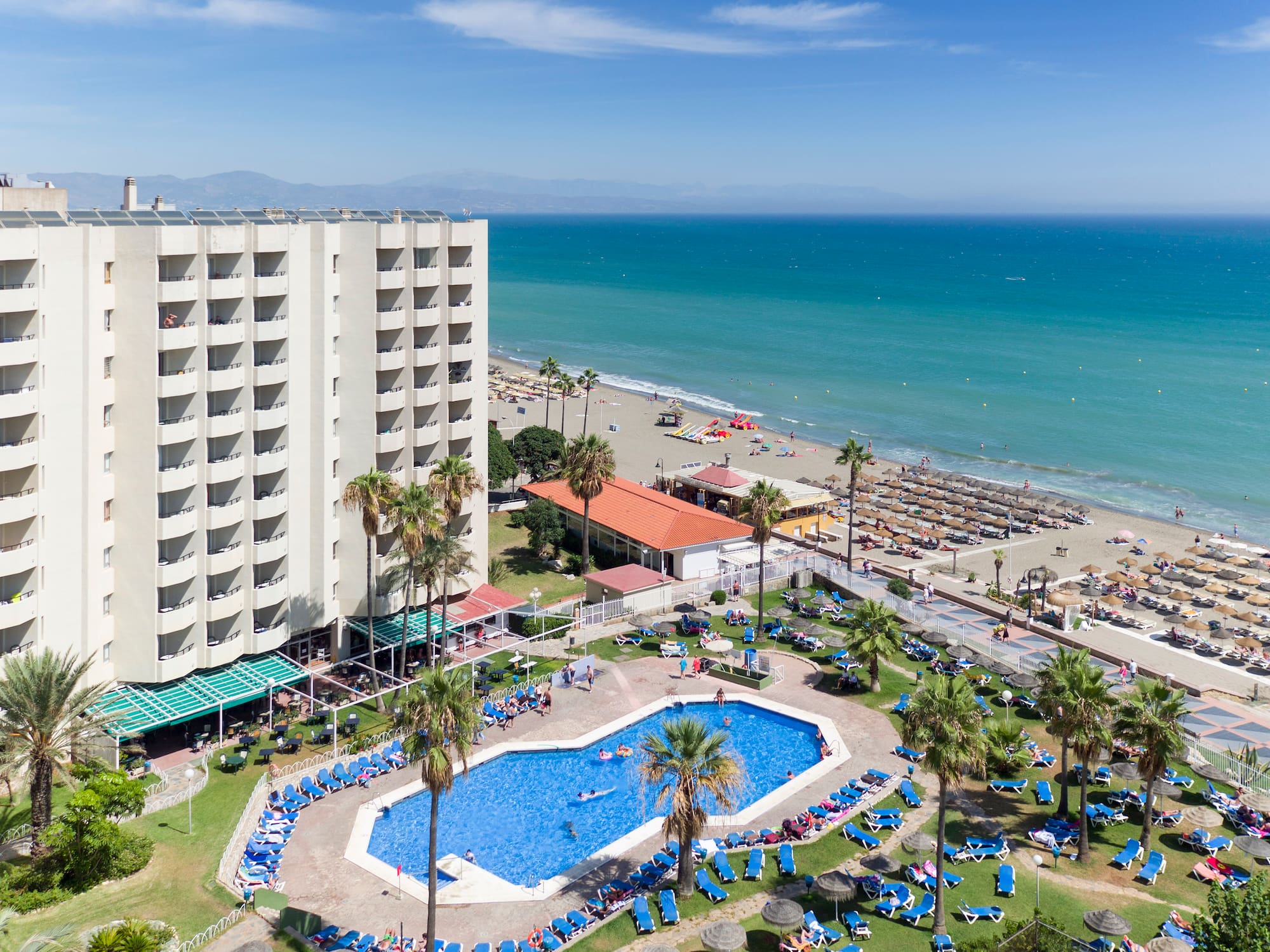 a swimming pool and a large building by the ocean