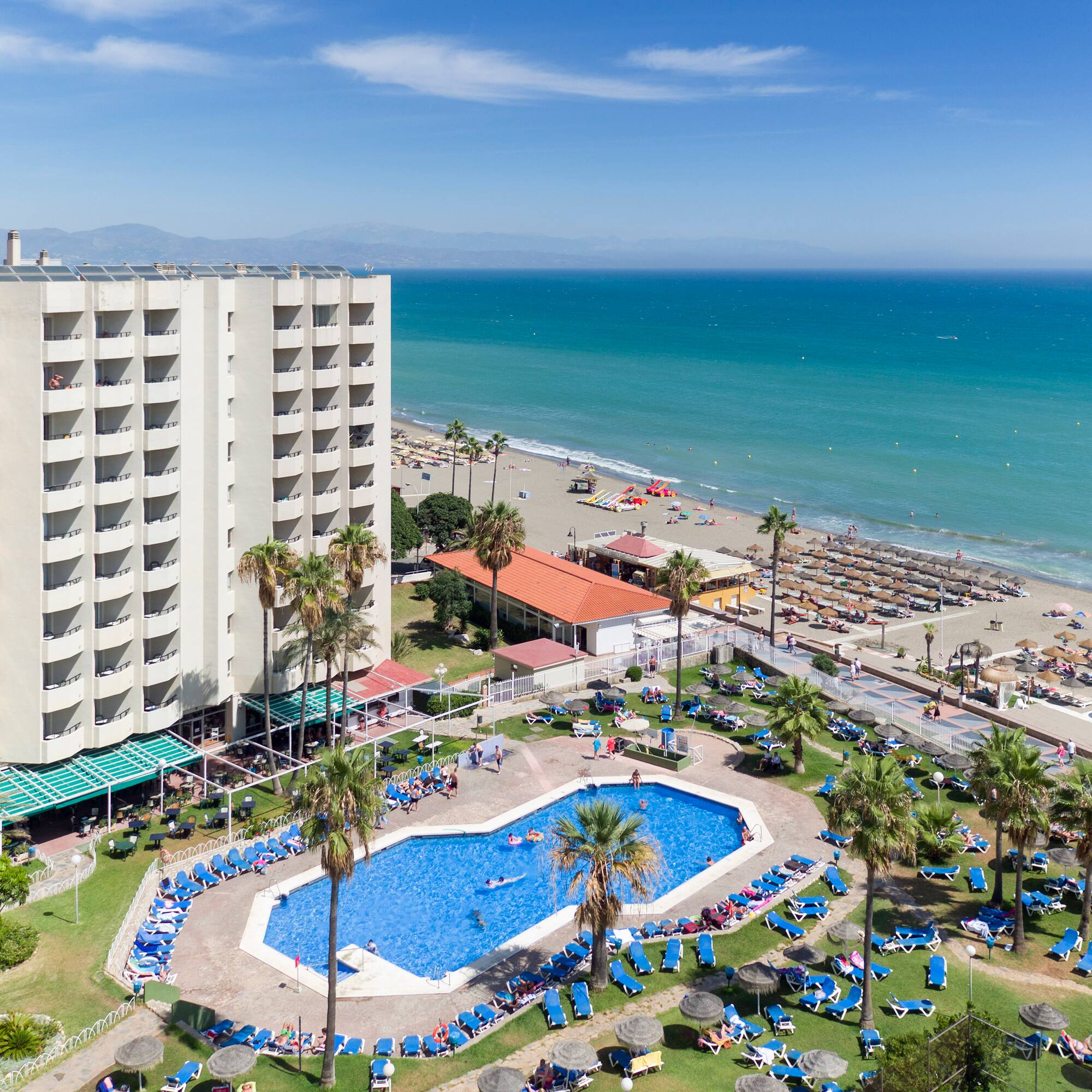 a swimming pool and a large building by the ocean
