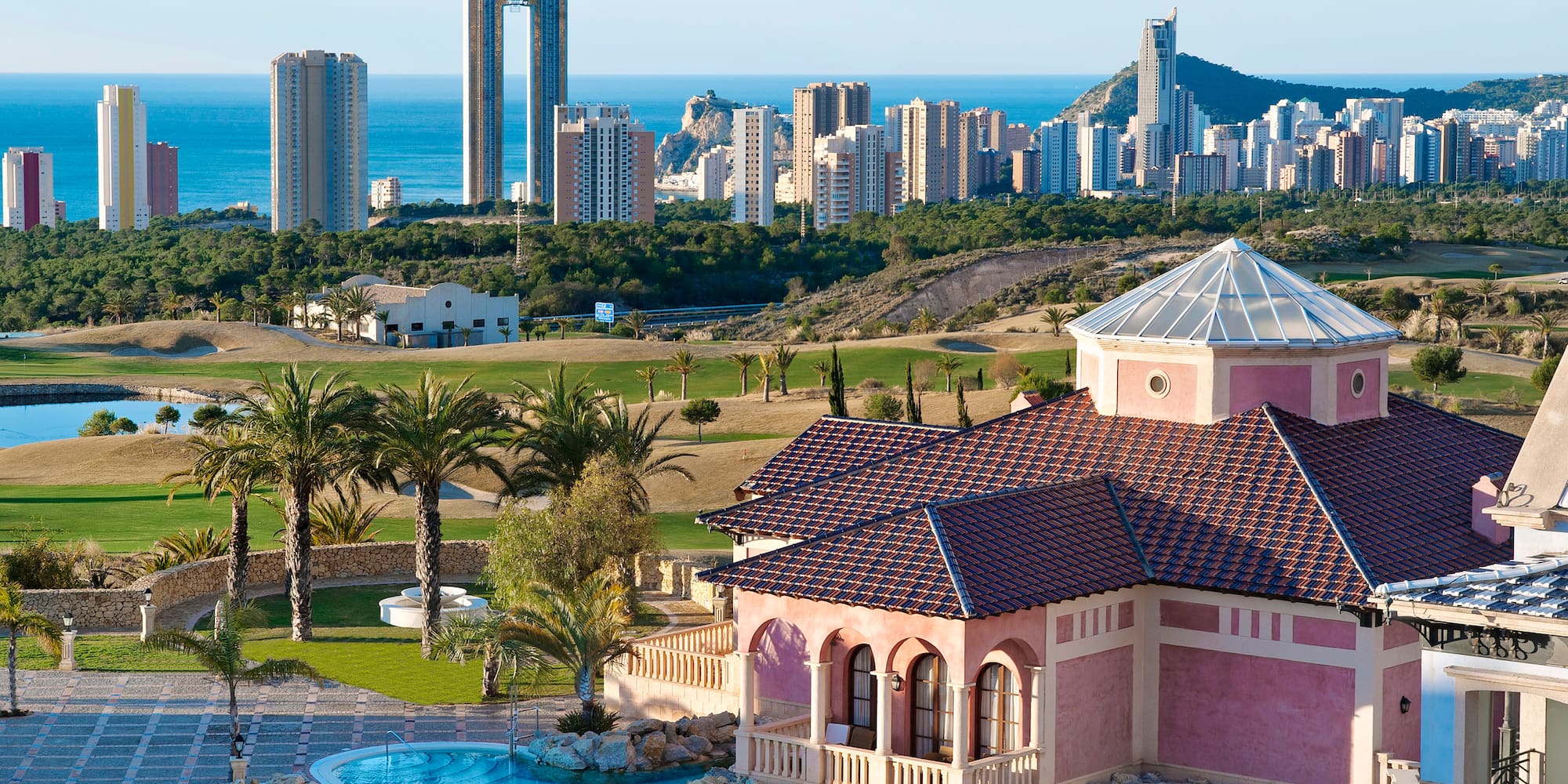 a house with a pool in front of a city