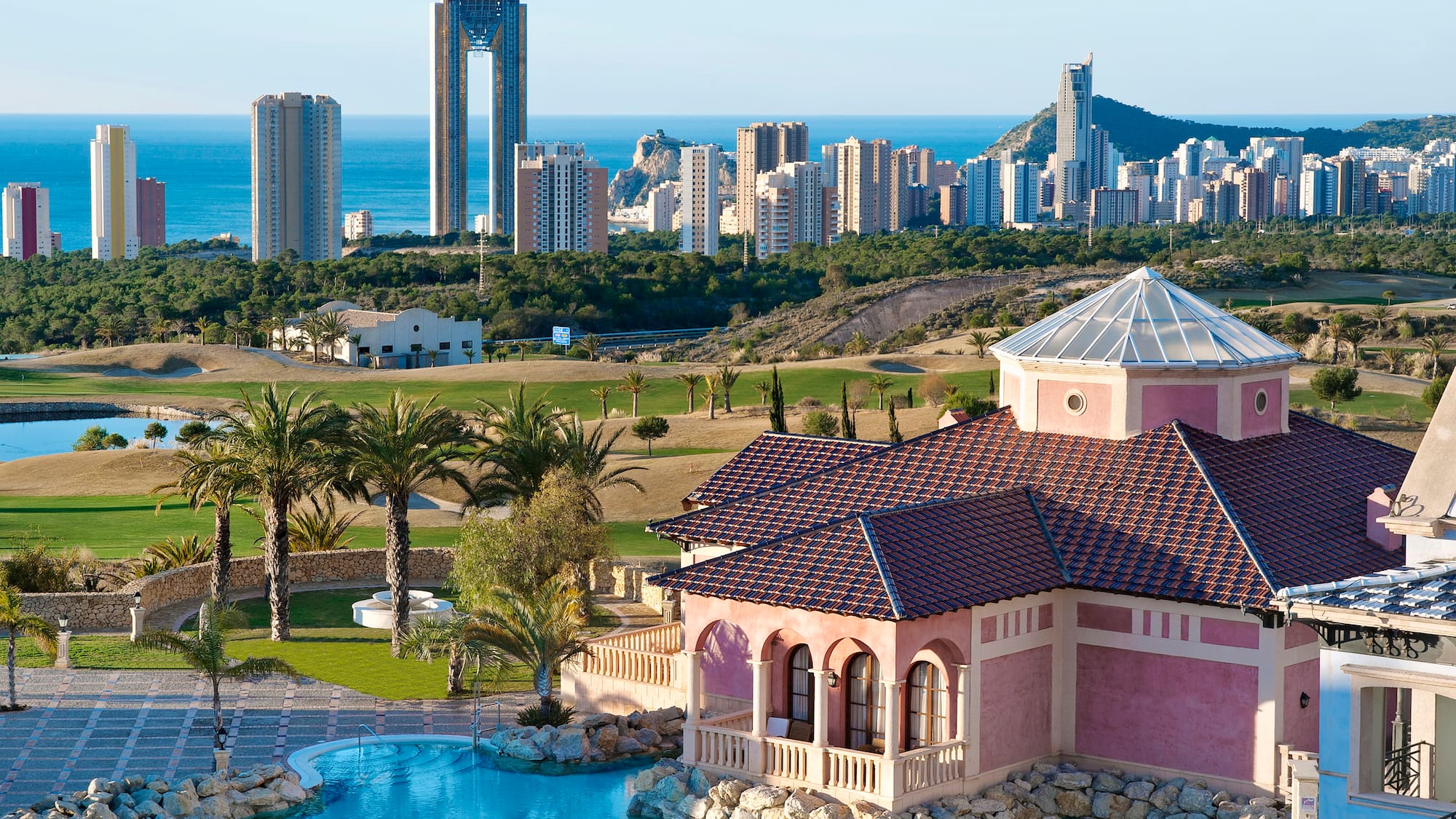 a house with a pool in front of a city