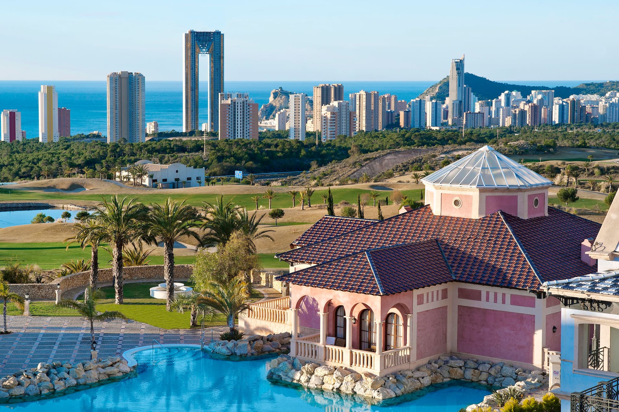 a house with a pool in front of a city