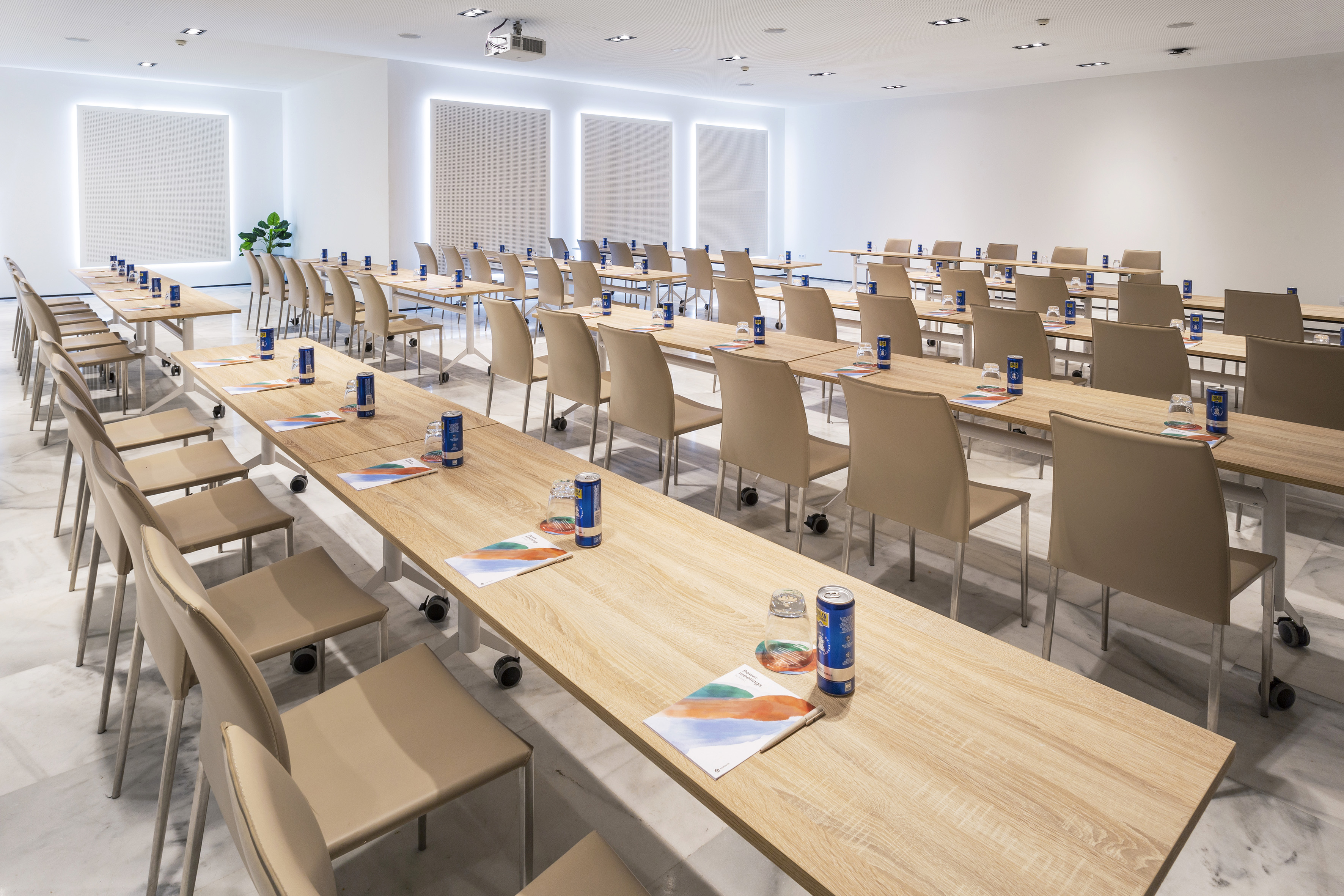 Modern meeting space with tables and chairs, equipped for conferences and events.